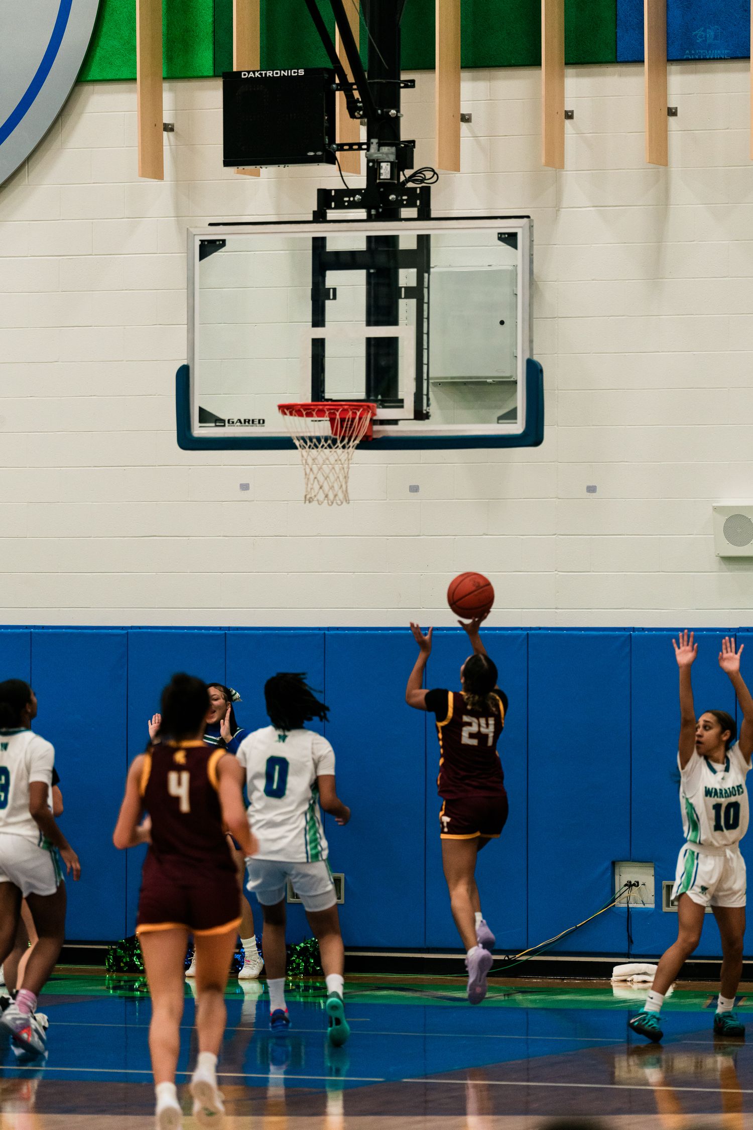 Turpin number 24 shoots a jump shot over Warriors defenders during a girls high school basketball game.