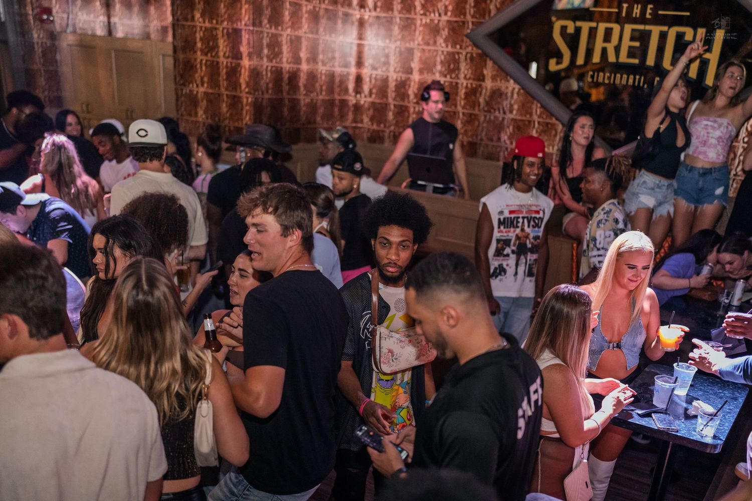 Diverse crowd of young people mingling and socializing at The Stretch Circuit nightclub event.