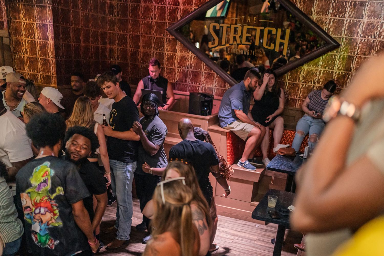 DJ performing at Stretch bar while crowd dances and socializes at nightclub event.
