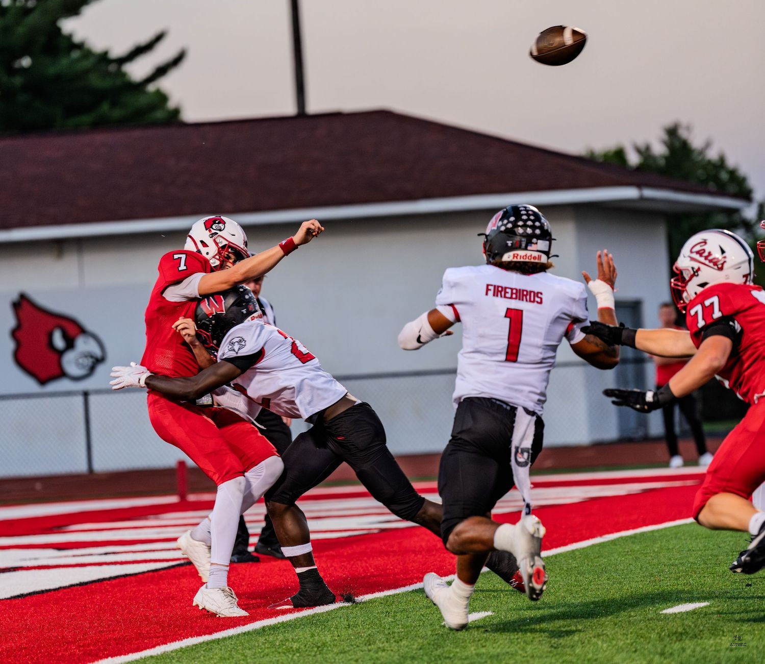 Colerain Cardinals quarterback #7 releases a pass under pressure during a high school football game.