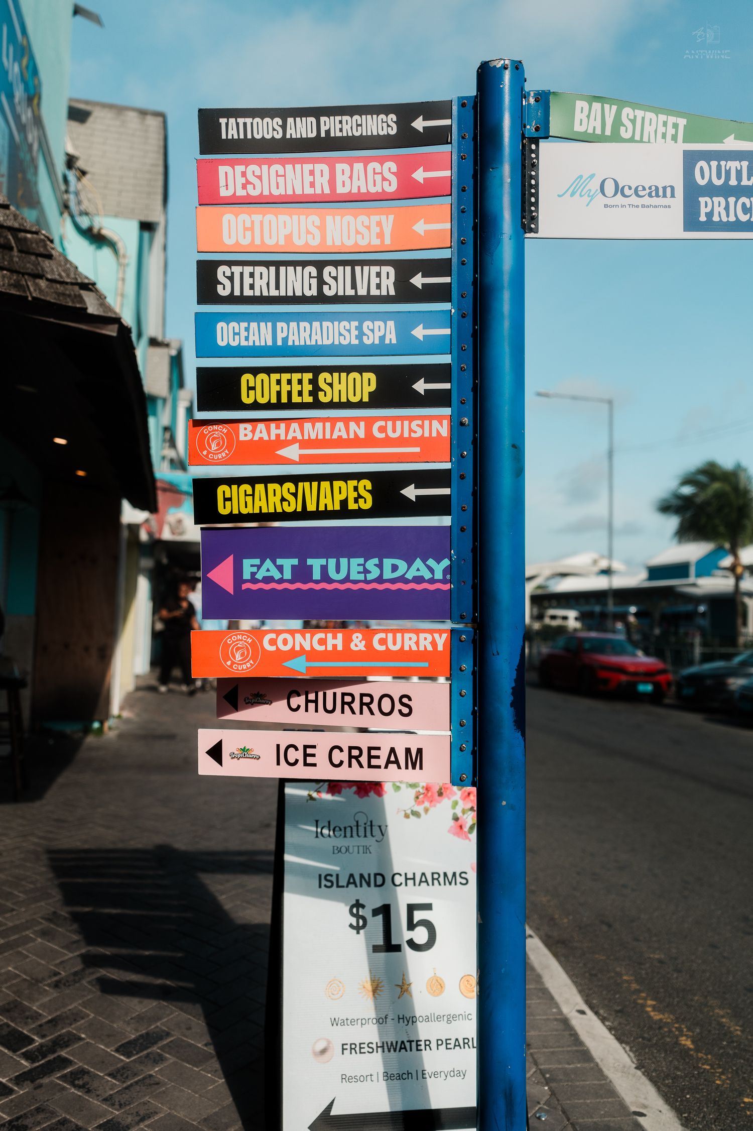 Colorful Bay Street directional sign listing shops and restaurants in Nassau, Bahamas.