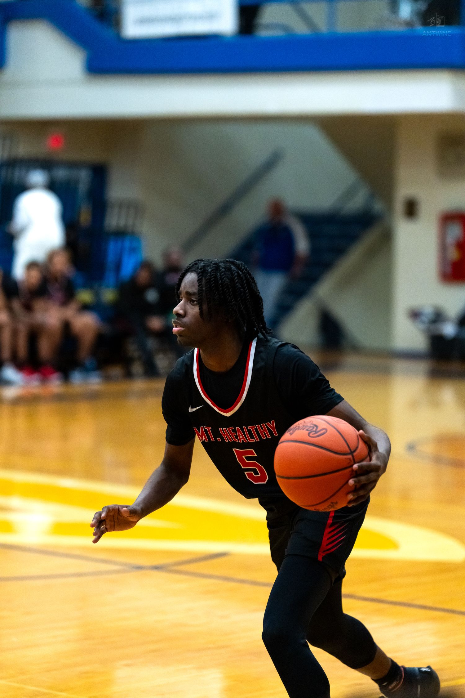 Mt. Healthy #5 drives with basketball during high school basketball game.