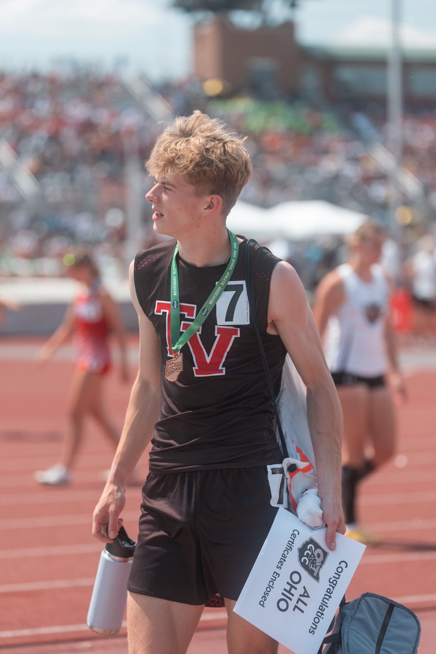 Young male track athlete wearing TV jersey and bronze medal at Ohio state competition.