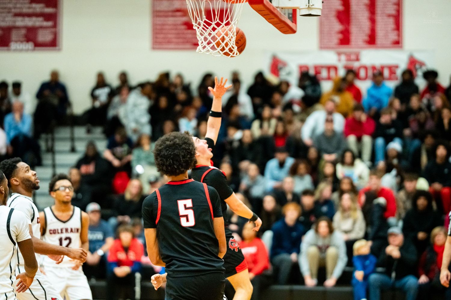 Colerain player #5 scores layup in front of packed Red Dome gymnasium crowd during high school basketball game.