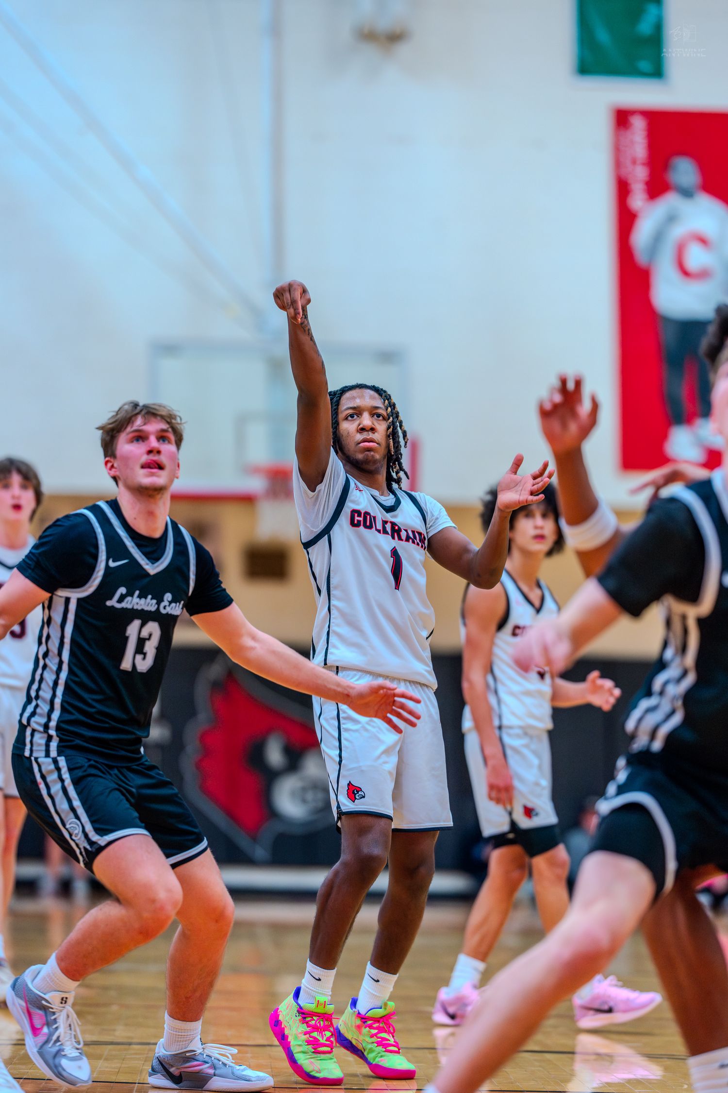 Colerain Cardinals #1 shoots over LaSalle defender #13 during competitive high school basketball game.