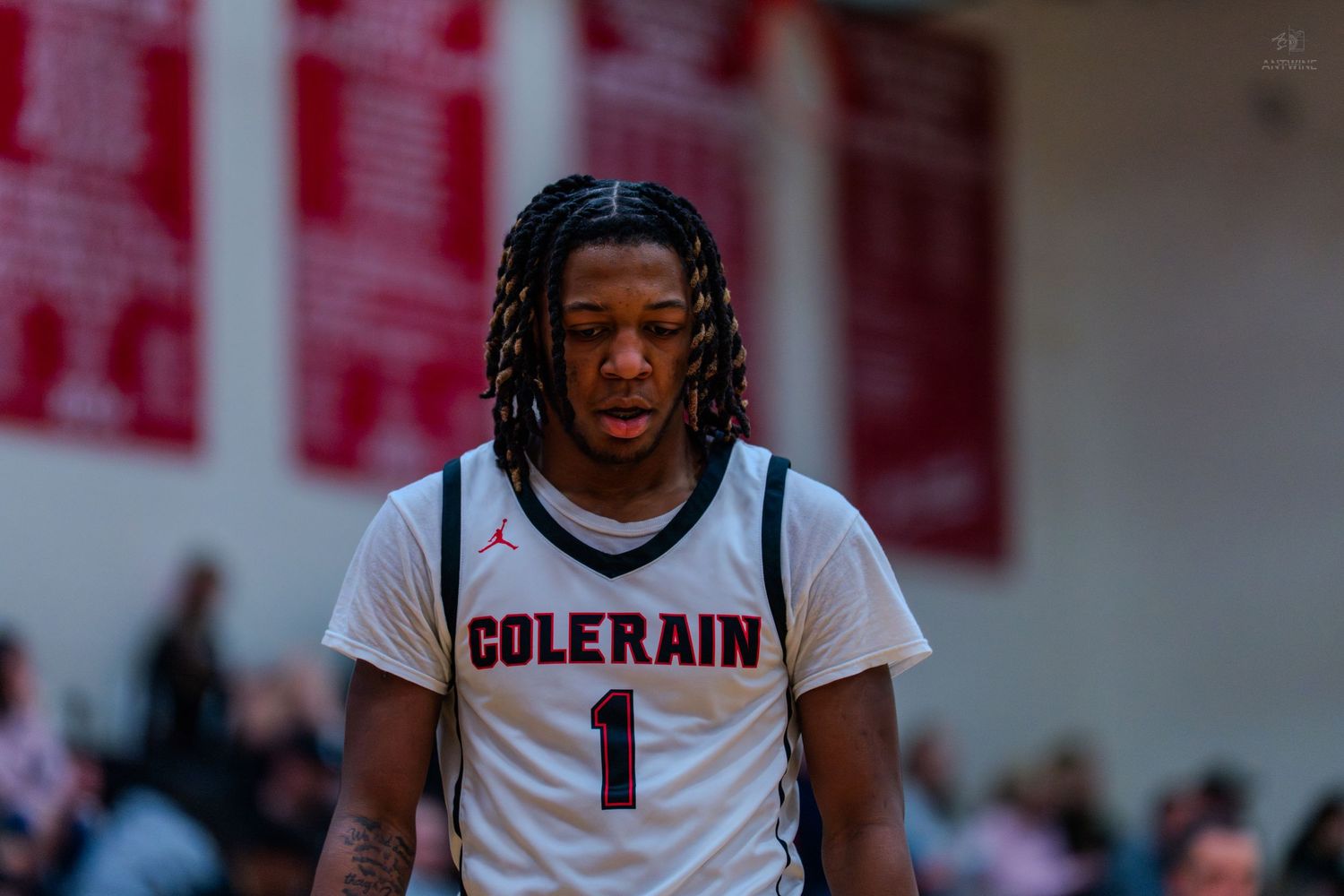 Colerain basketball player number 1 with braids looks down during a high school game.