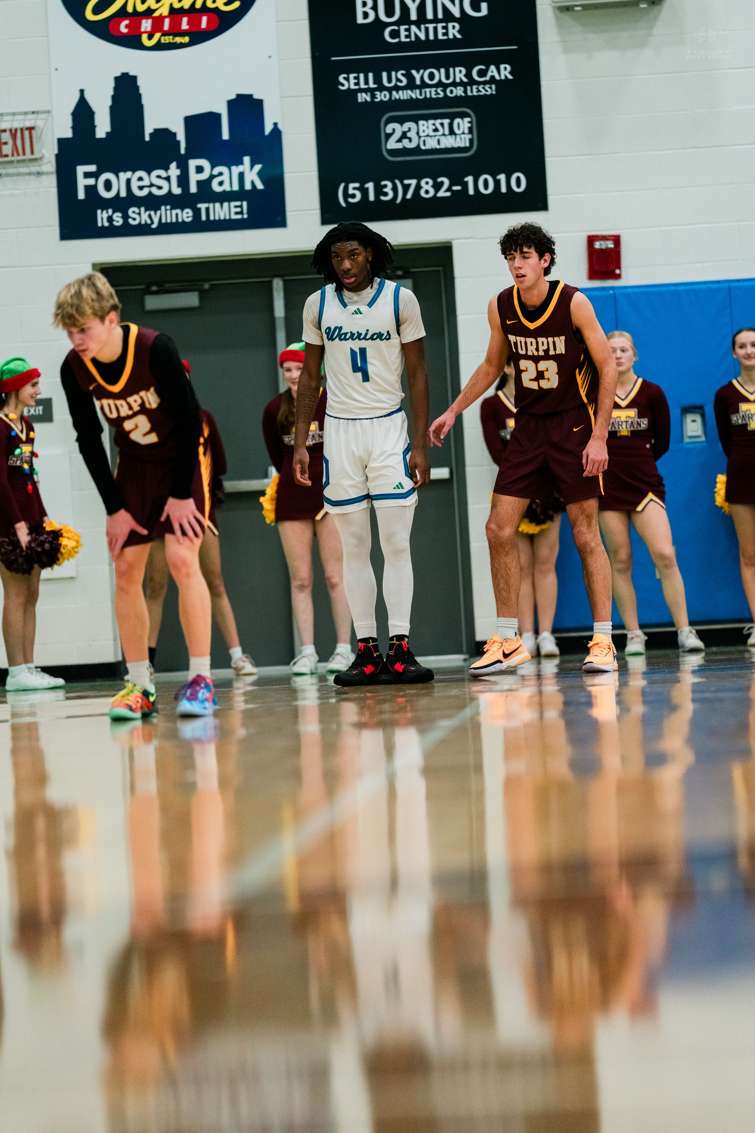 Turpin and Warriors basketball players line up during a free throw attempt in a high school gymnasium.