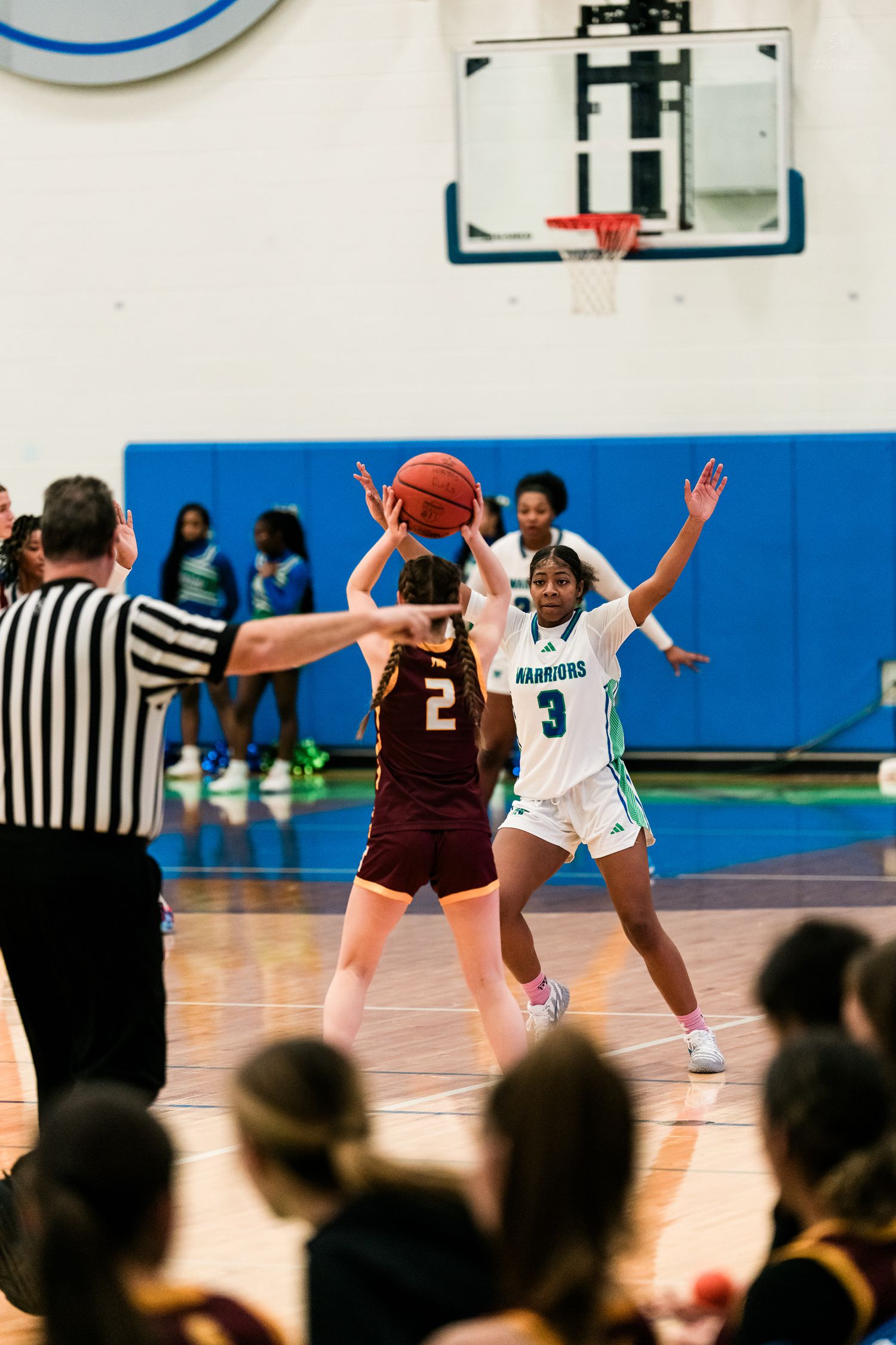 A Warriors defender contests a shot by a Turpin player as a referee watches during a girls high school basketball game.
