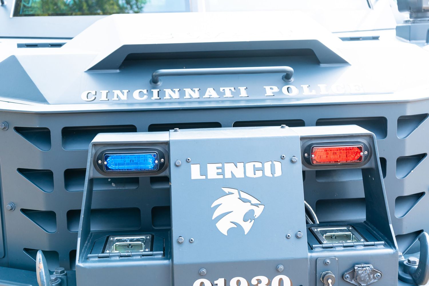 Cincinnati Police Lenco armored vehicle close-up showing blue and red lights and lion logo emblem.