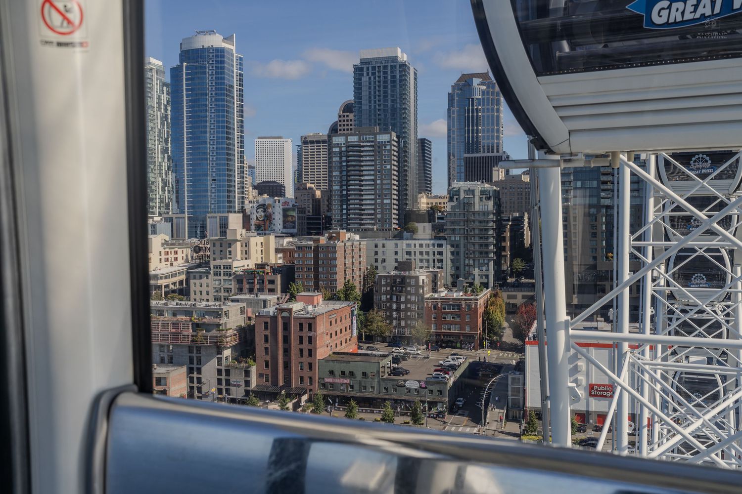 Seattle city skyline viewed through a Great Wheel ferris wheel gondola window on a sunny day.