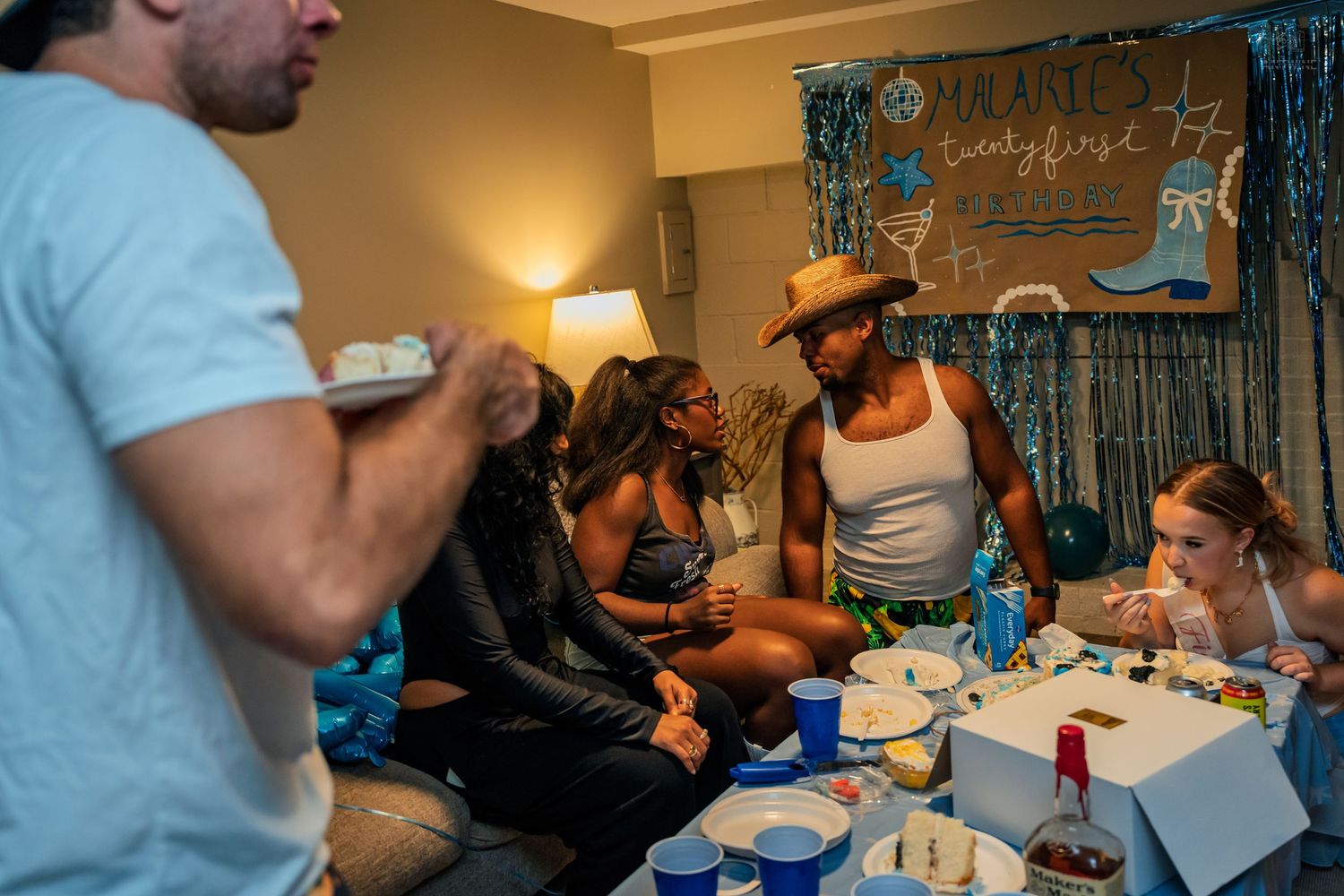 Group of friends gathered around a decorated table at Malarie's 21st birthday party celebration.