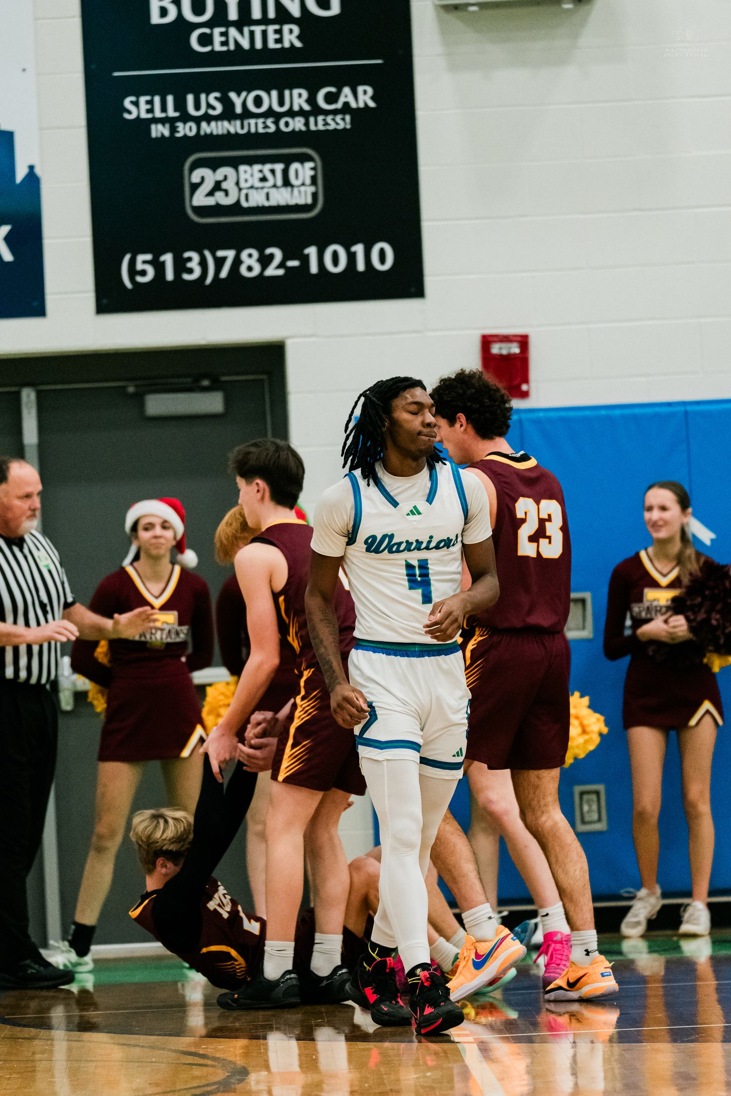 Warriors #4 player celebrates amid Turpin defenders during high school basketball game in gymnasium.