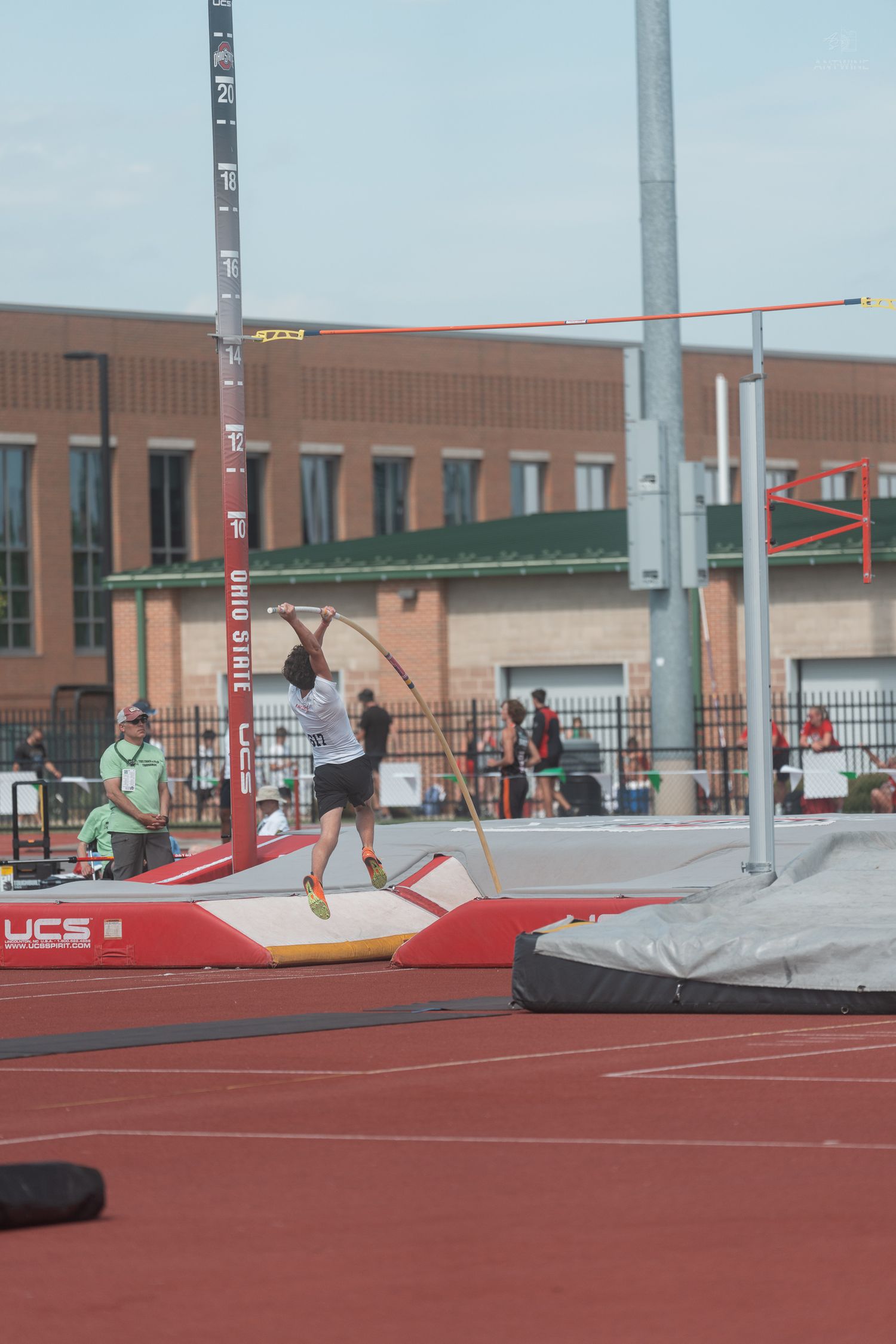 Athlete plants pole during a pole vault attempt at an Ohio State track and field meet.