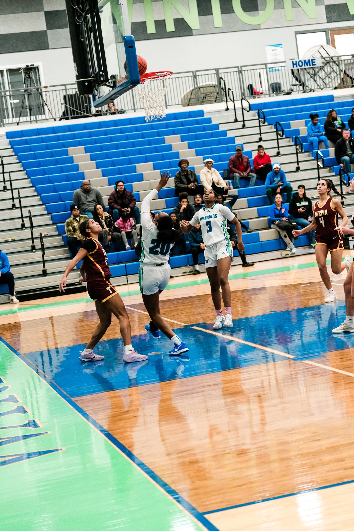 Harbors girls basketball player #3 drives to the basket against Turpin defenders in high school game.