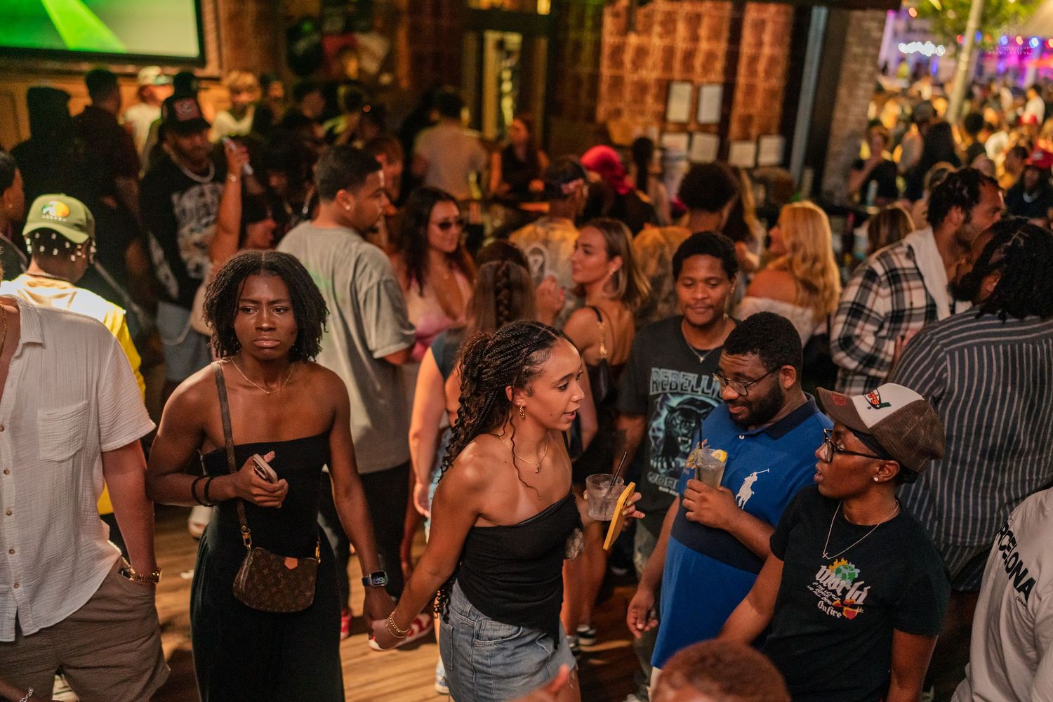 Diverse crowd of people socializing at an outdoor nighttime party event.