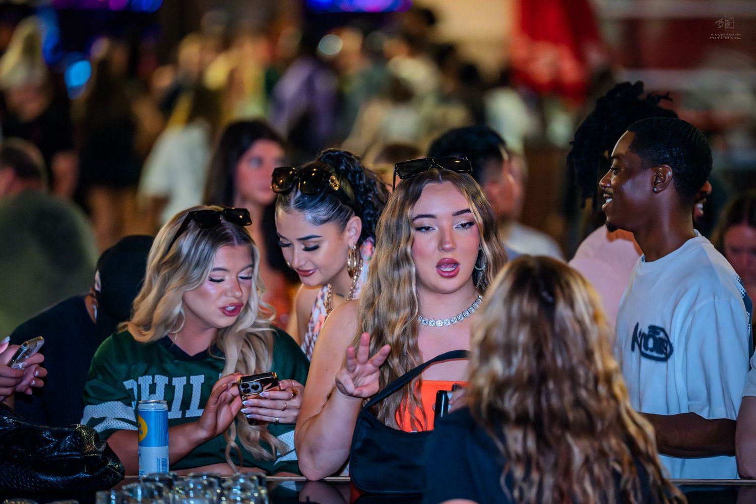 Group of stylish young women socializing at a lively nightclub.