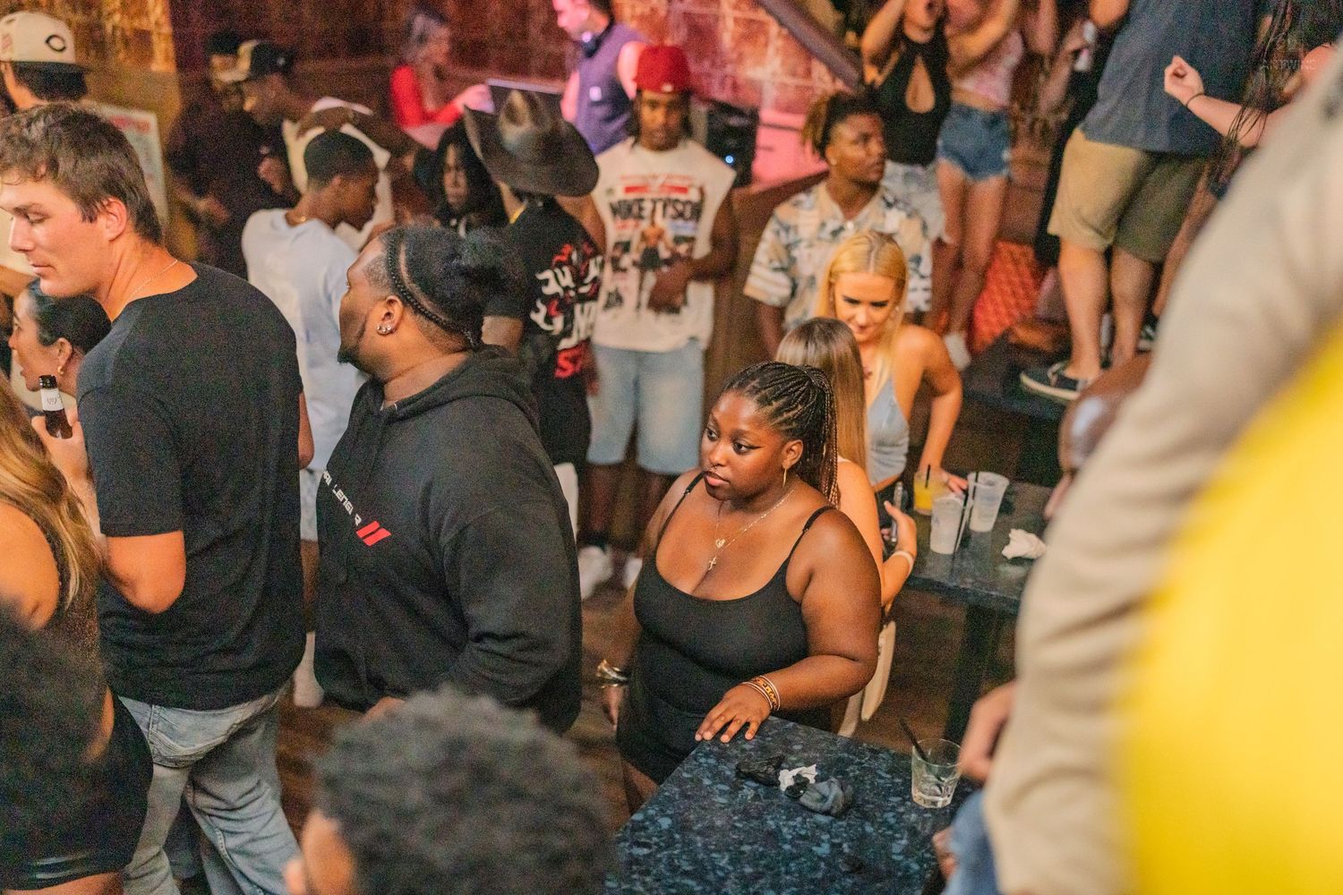Diverse group of guests mingling at a lively outdoor nightlife party event.