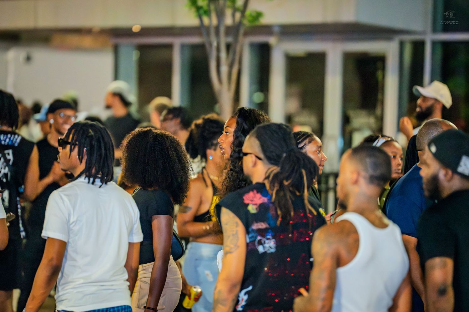 A diverse crowd of people socializing and dancing at an outdoor nighttime event.