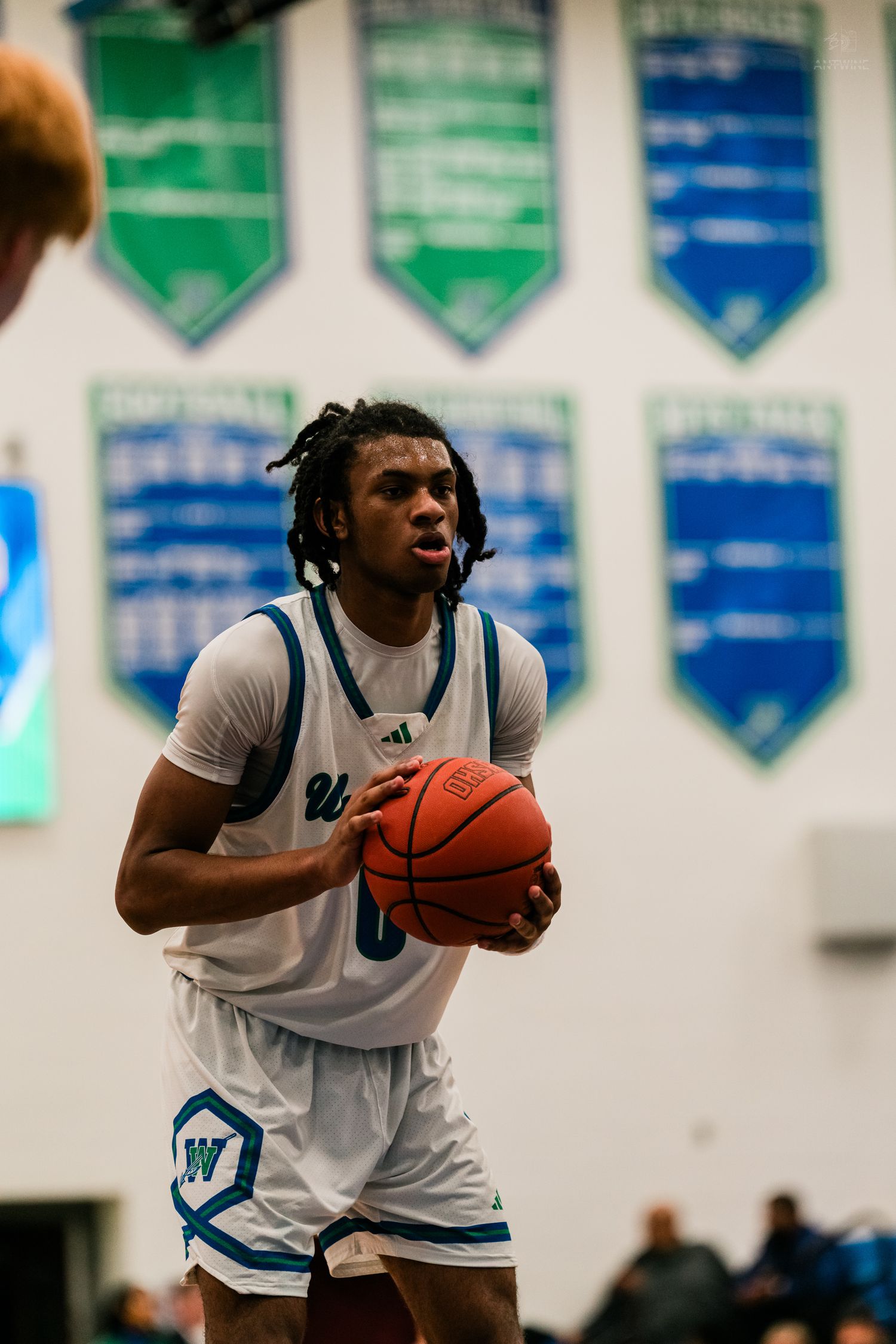 Warriors basketball player #0 in white Adidas uniform prepares to shoot a free throw in a gymnasium.