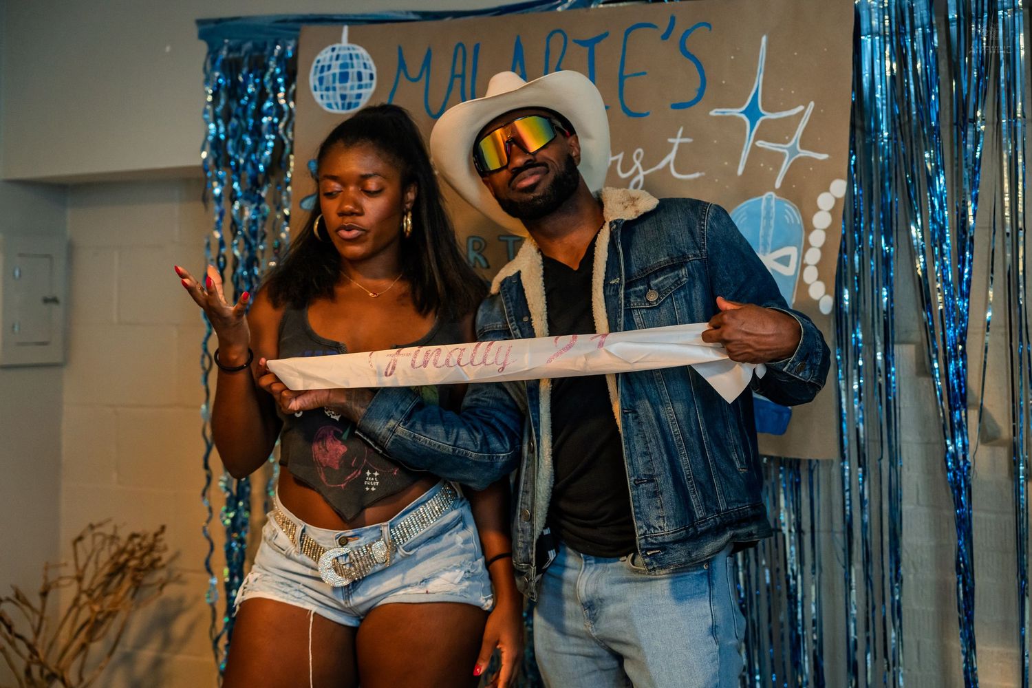Two party guests pose with a decorative sash at Malarie's birthday party.