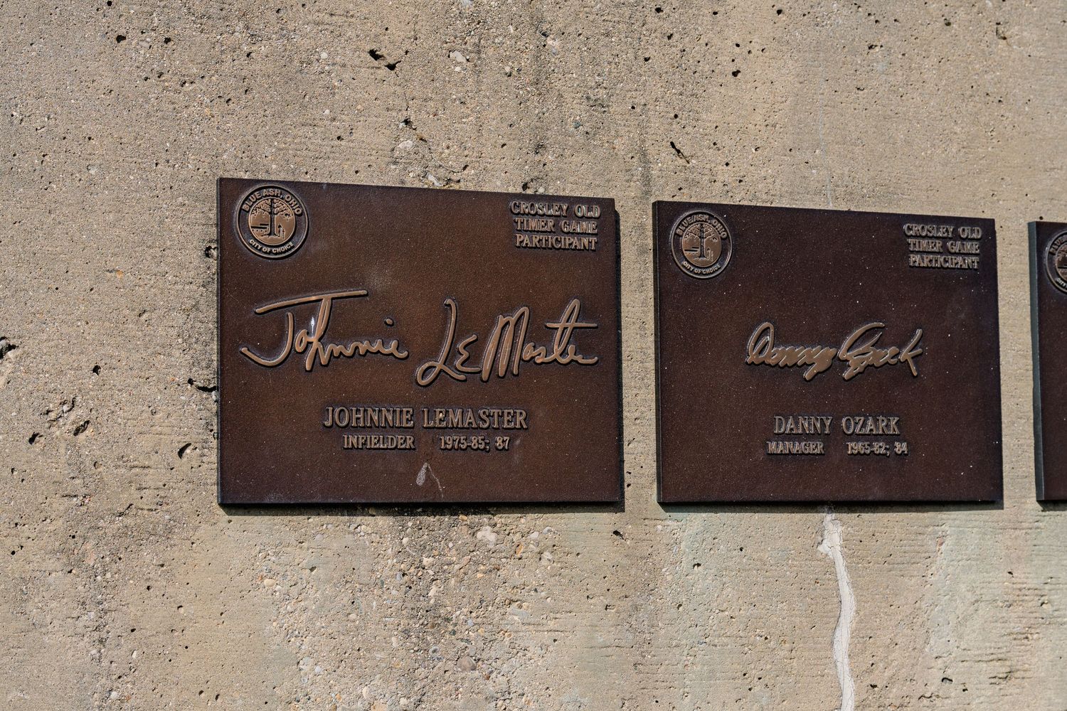 Bronze plaques honoring Johnnie LeMaster and Danny Ozark on a stone wall.