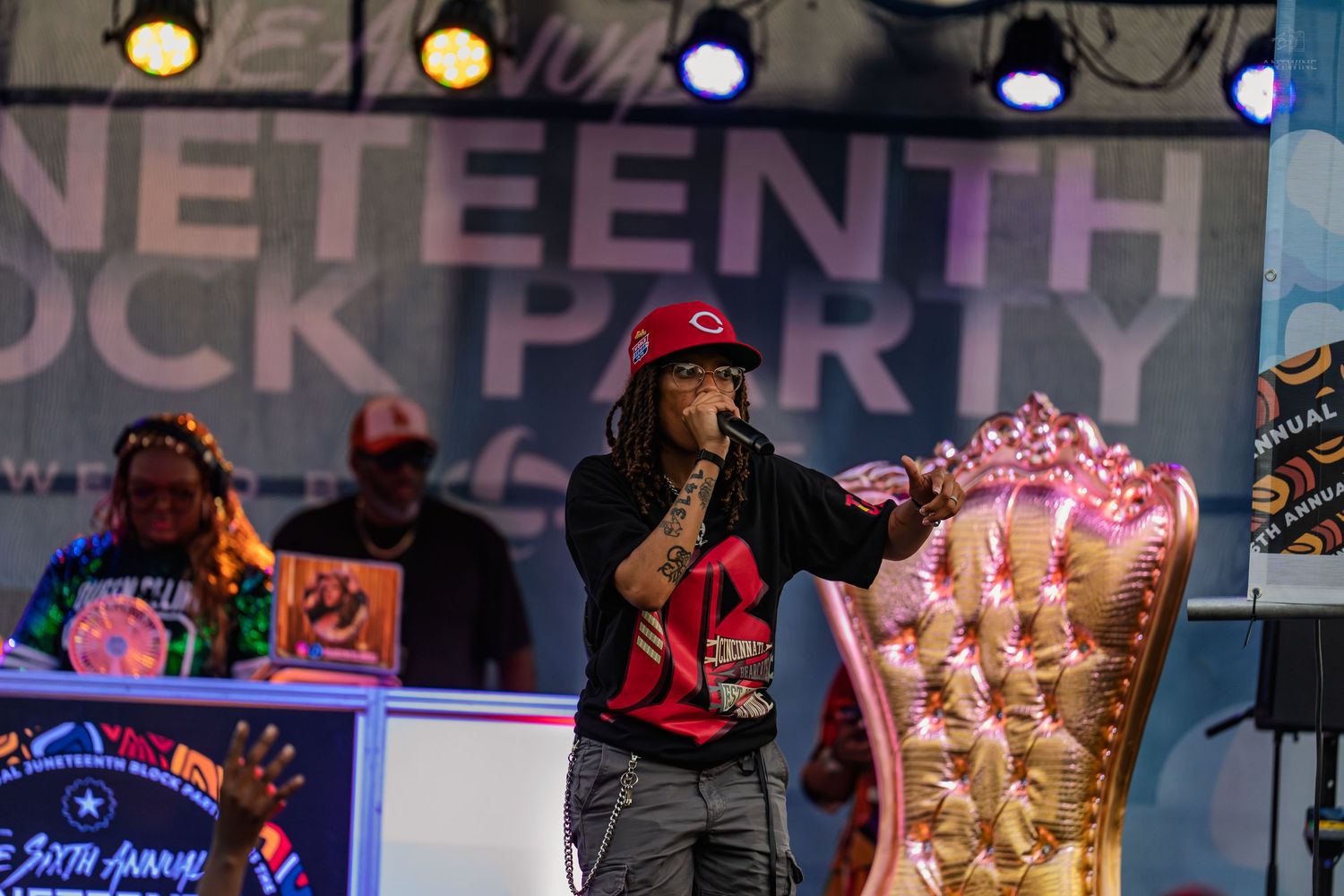 Performer on stage at the 6th Annual Juneteenth Block Party event with pink throne chair.