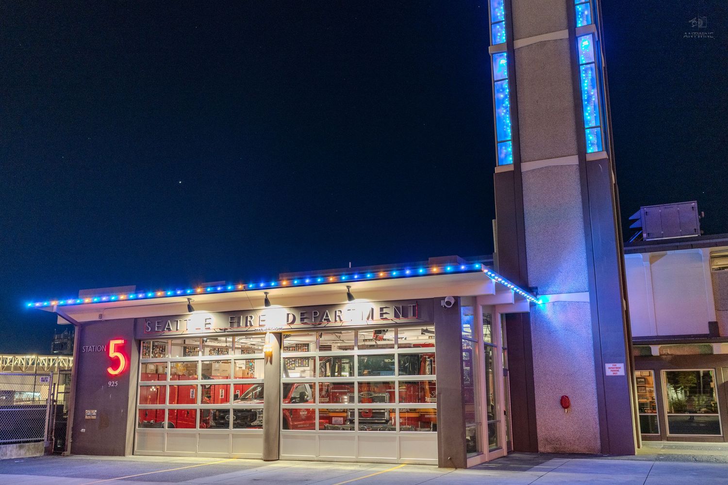 Fire station number 5 decorated with holiday lights at night.