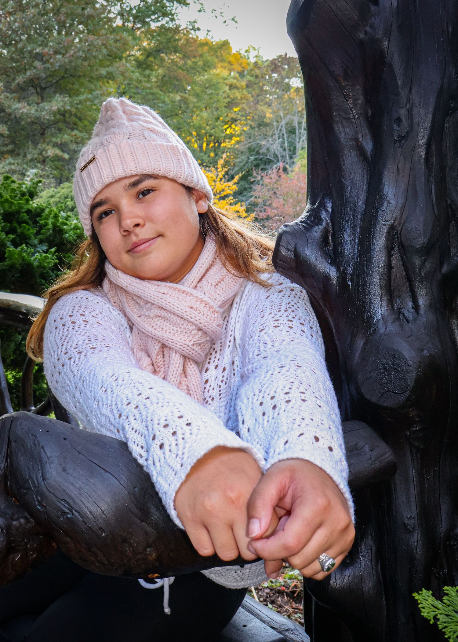 A female looking into the distance with her hands folded.
