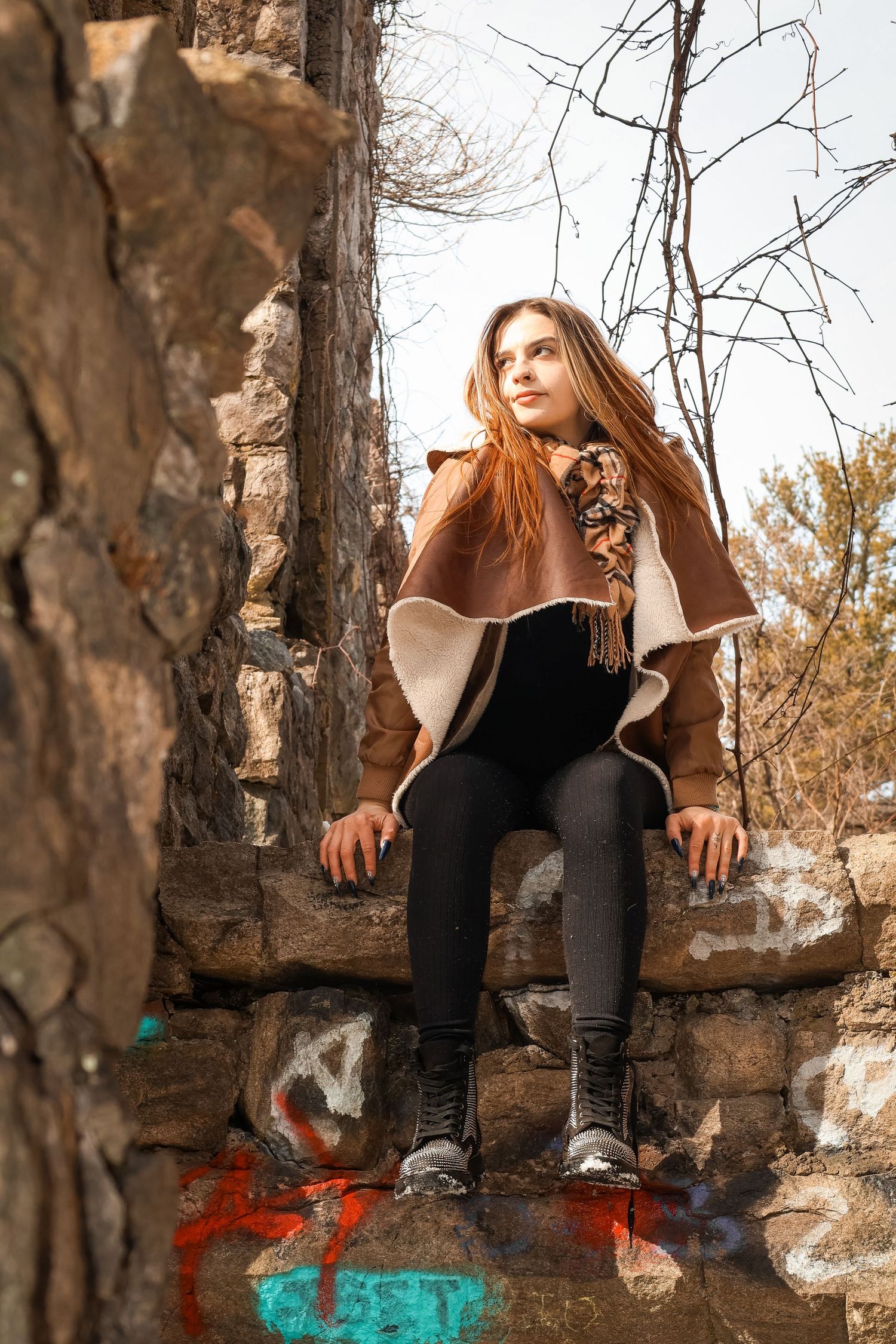A female sitting on an old part of a castle structure