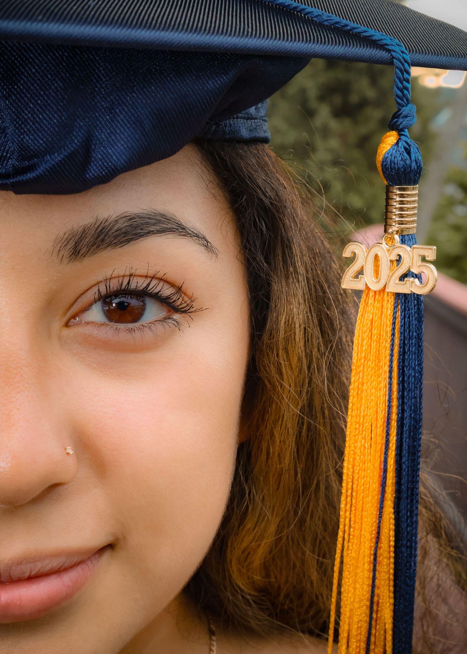 A close up headshot of a female that graduated in 2025 and is wearing her graduation hat.