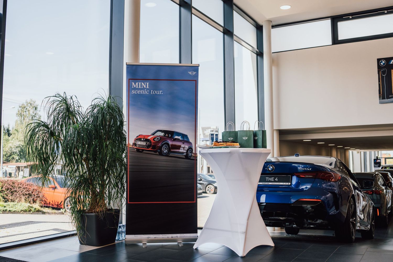 MINI Countryman promotional display banner in modern BMW dealership showroom interior.
