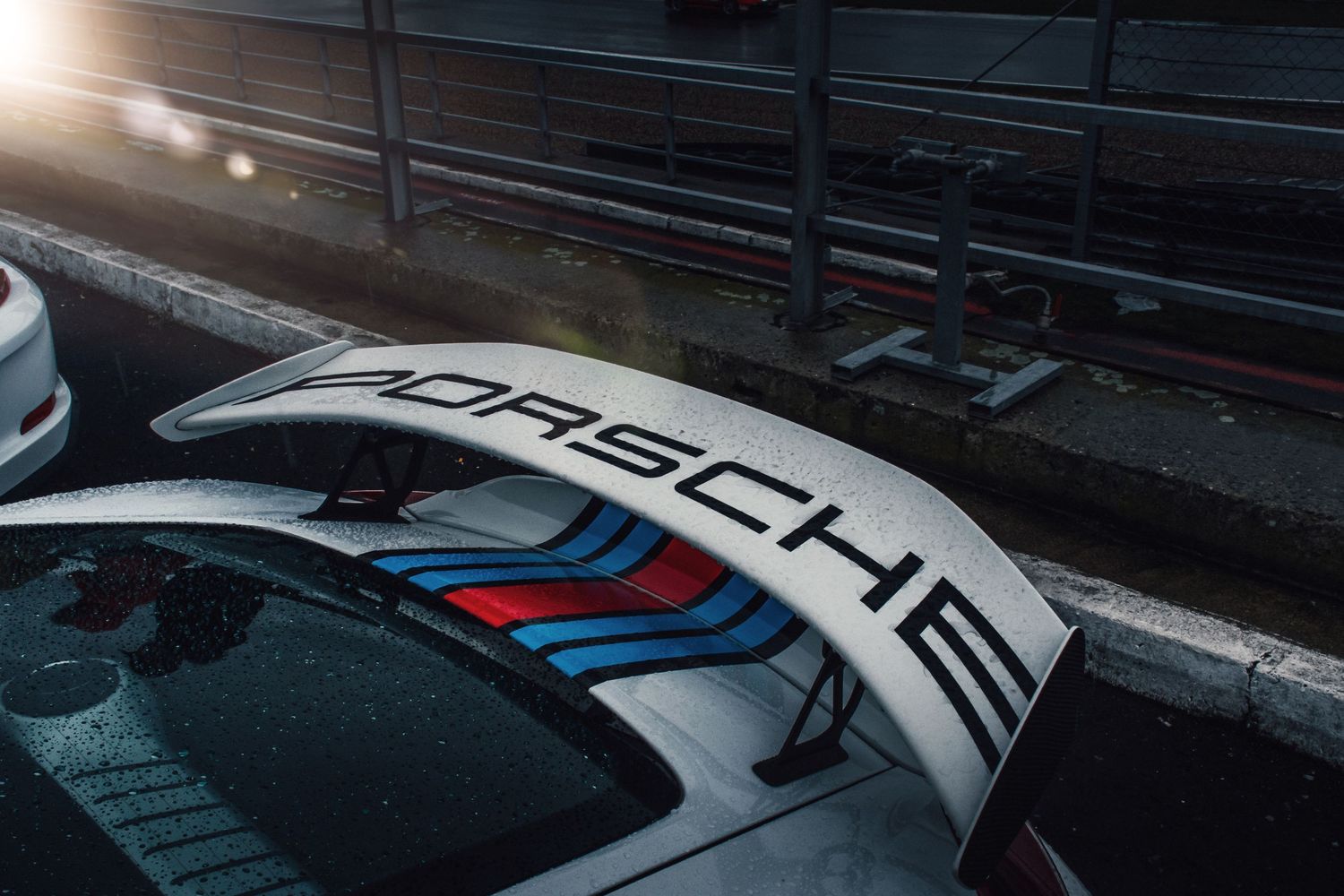 Top view of a Porsche 911 GT3 rear wing featuring Martini racing livery stripes.