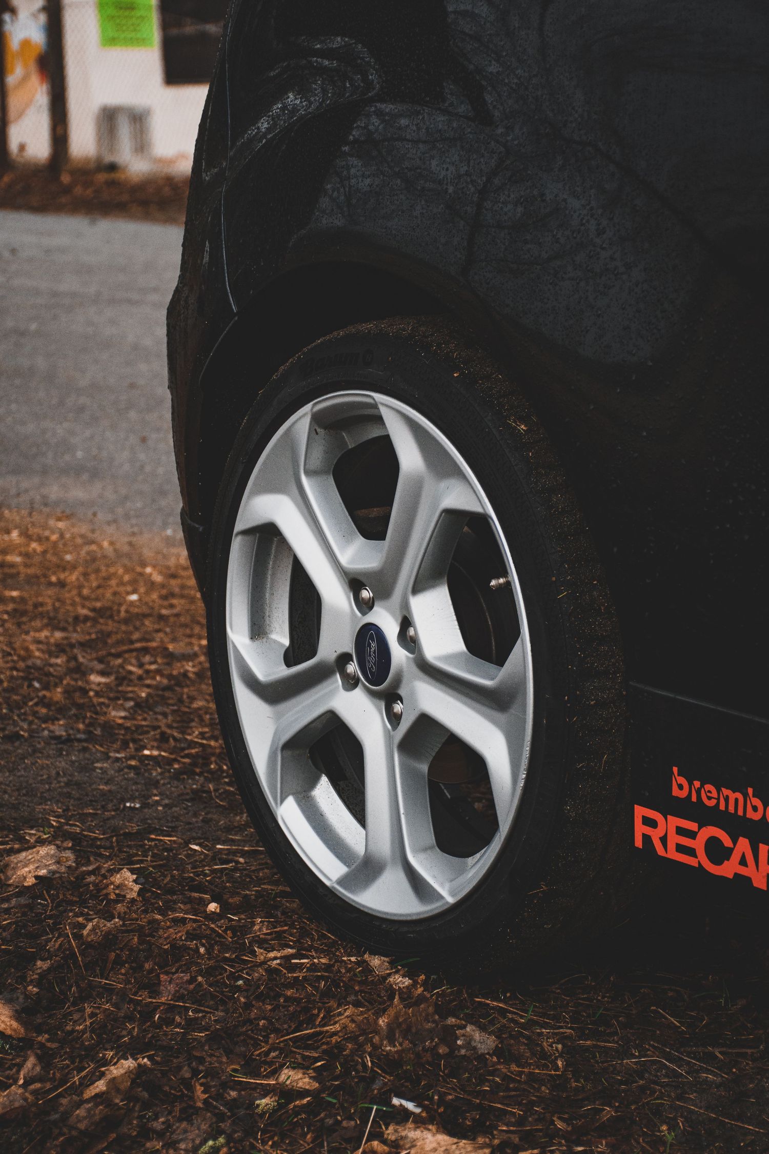 Silver Ford alloy wheel with Brembo and Recaro stickers on a black Ford Fiesta ST.