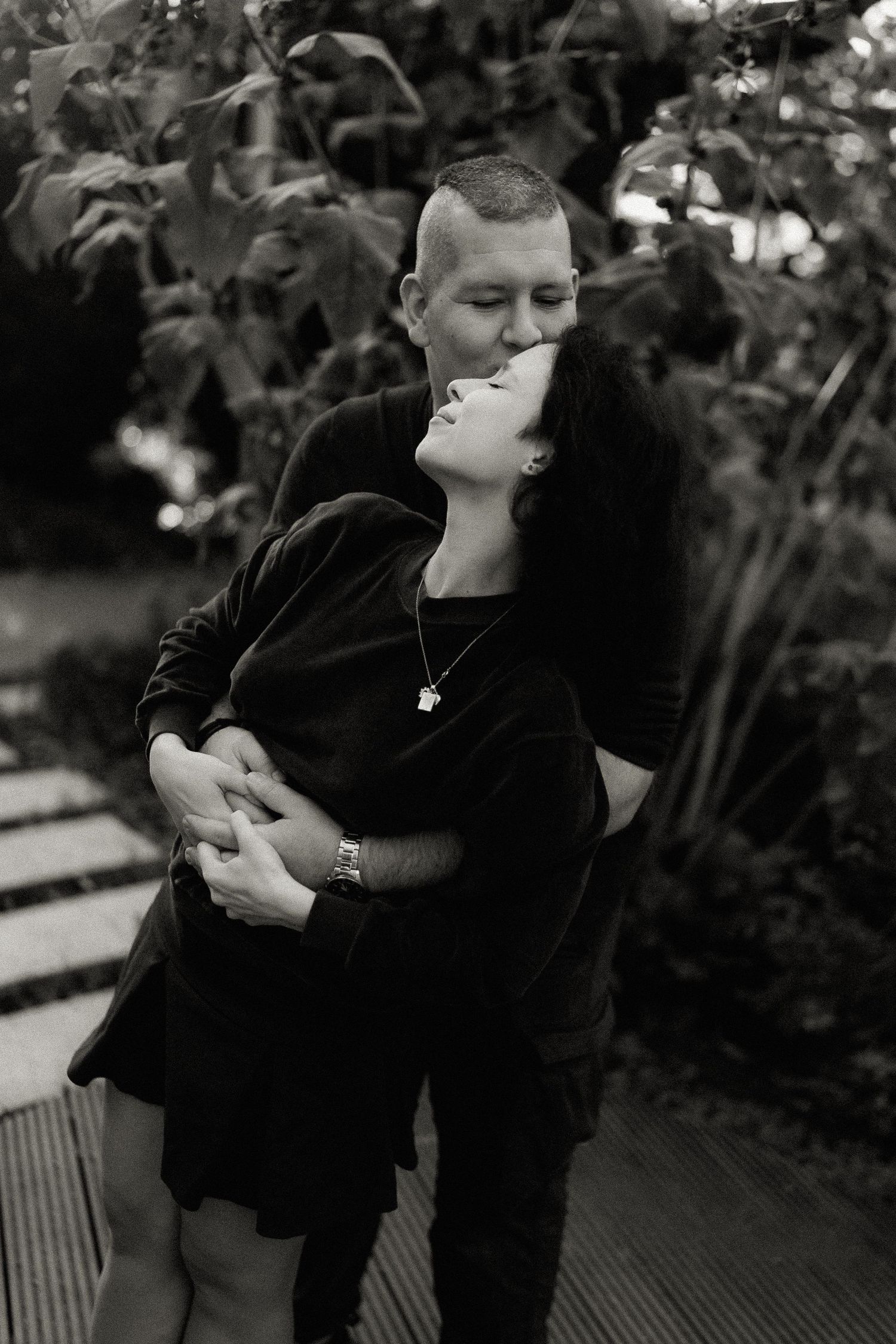 Romantic black and white moment between couple in outdoor garden.
