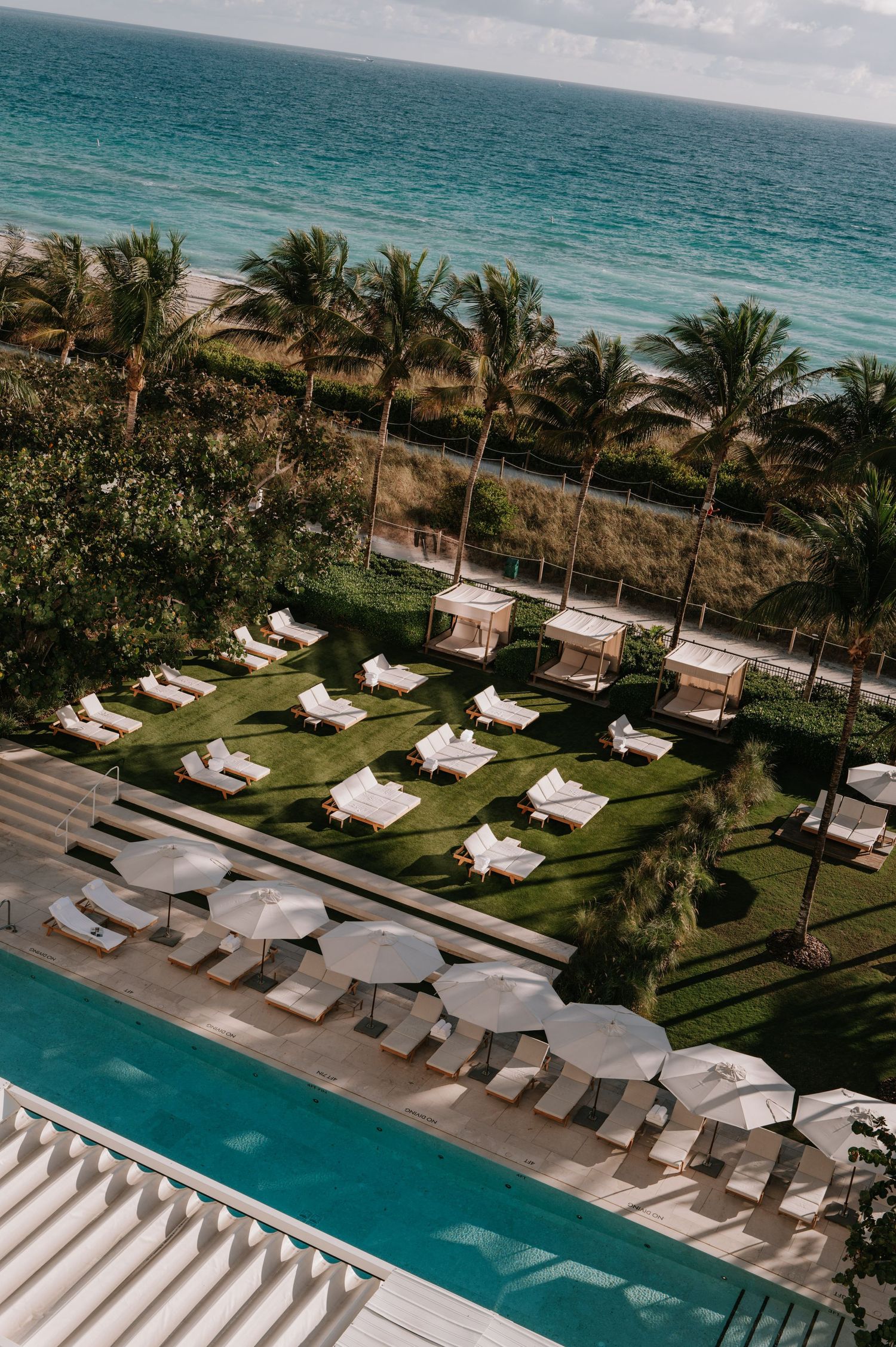 A sunny private pool day with high-end cabanas at a historic hotel by the beach