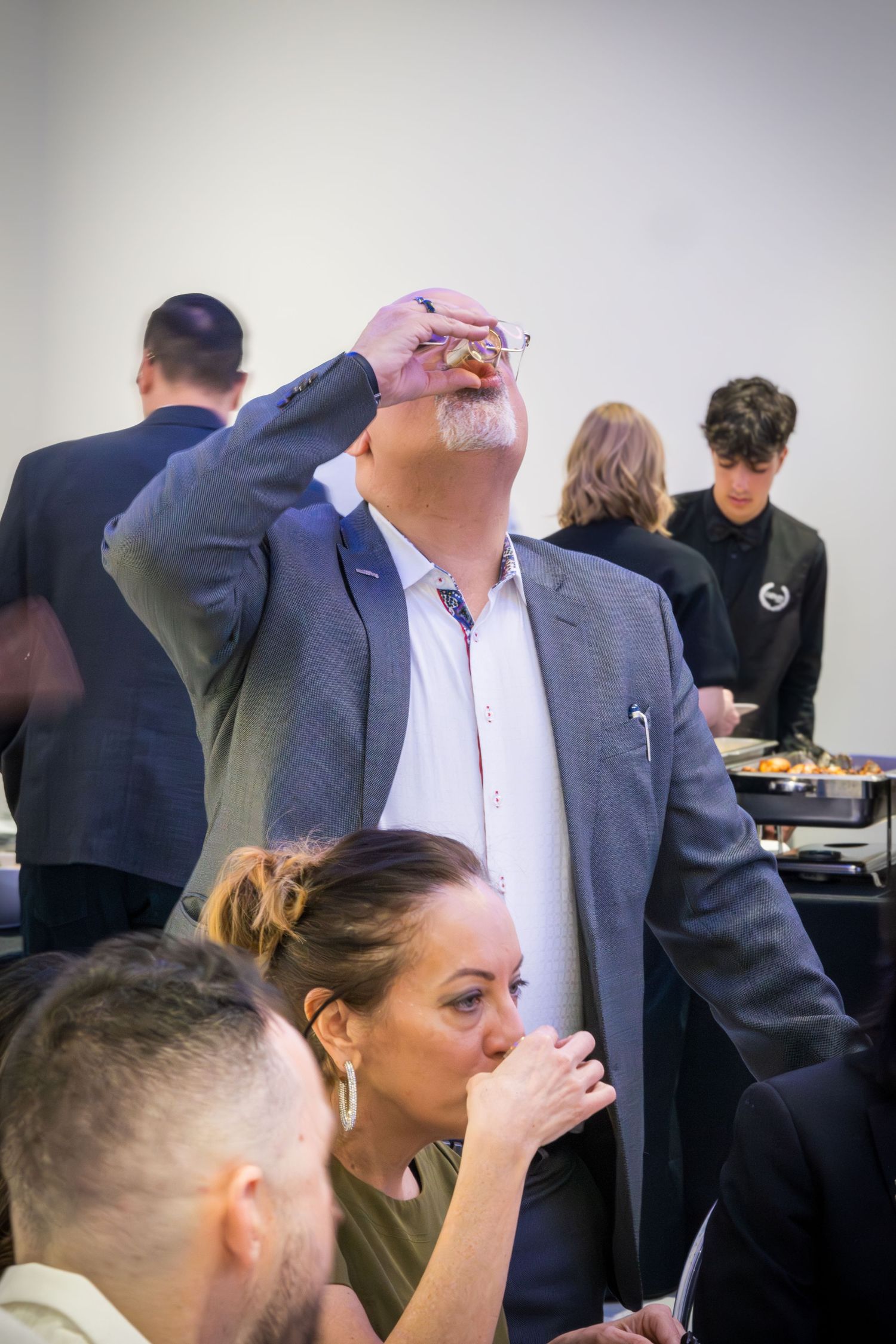 People at a social event taking shots of drinks together.