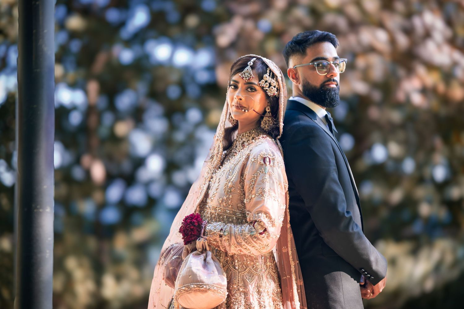 Newlywed couple shares intimate moments during their outdoor wedding photoshoot in a lush garden setting.