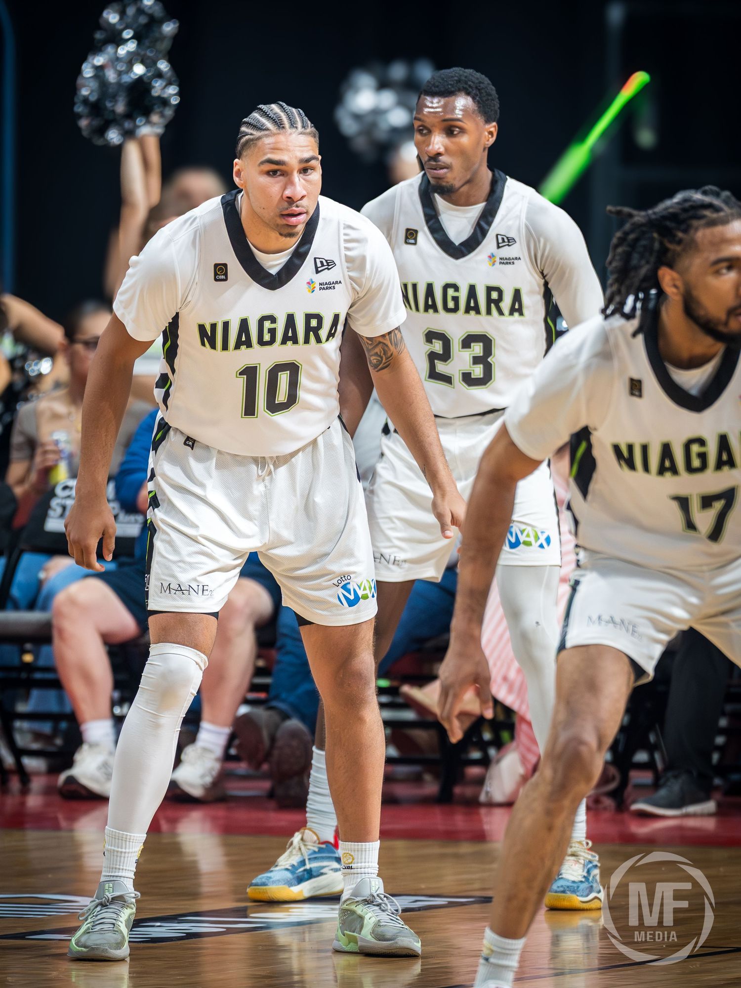 Niagara basketball players in white uniforms with numbers 10, 23, and 17 on the court during a game.
