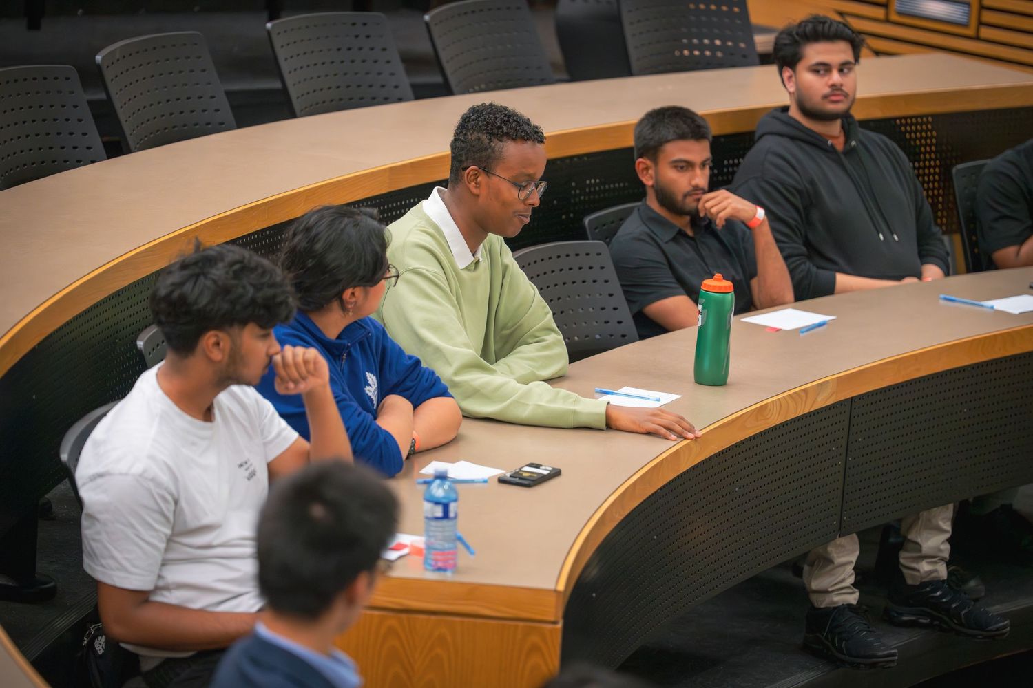 Audience members seated in tiered classroom during business presentation.