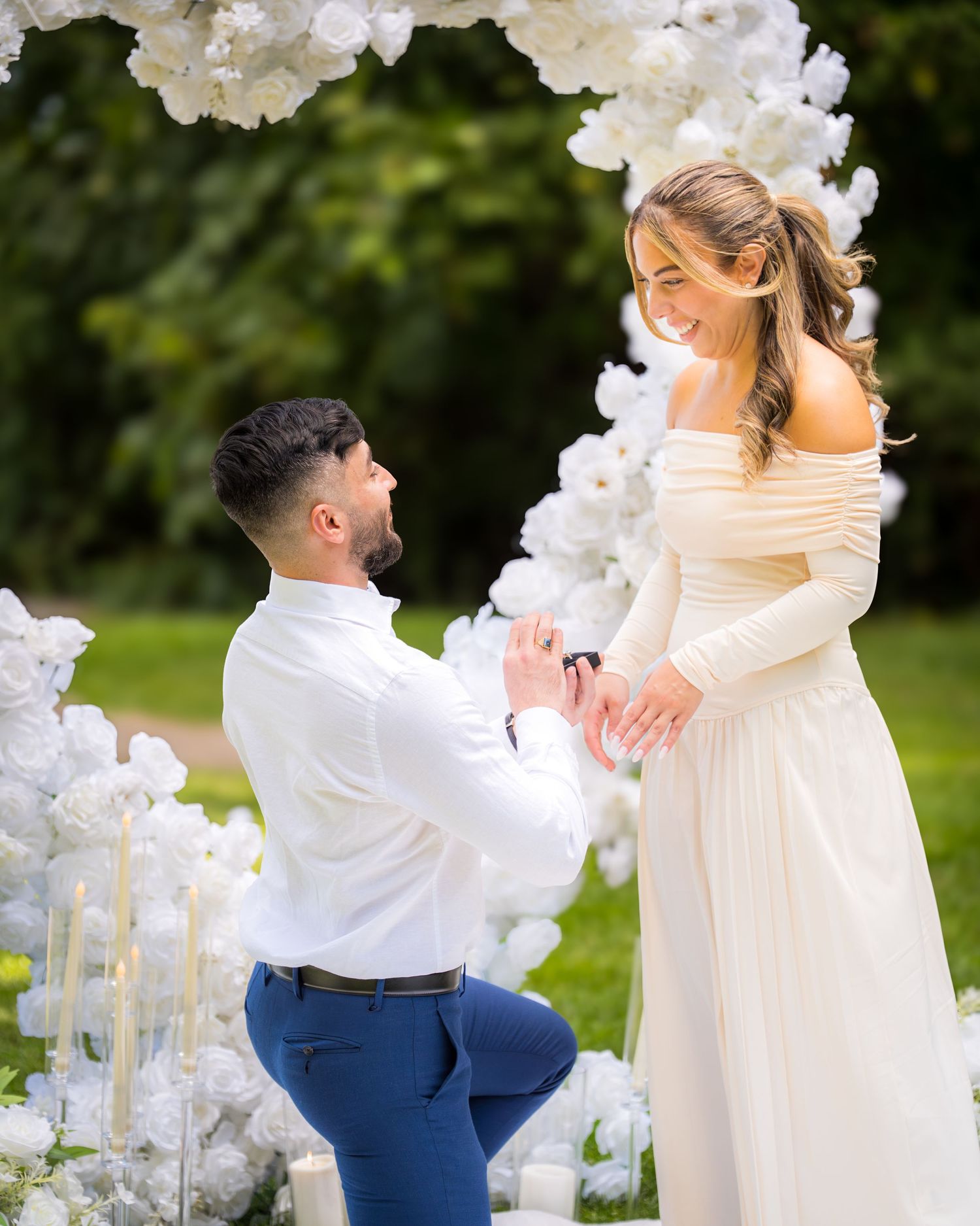 A romantic dance moment captured under a beautiful white floral wedding arch.