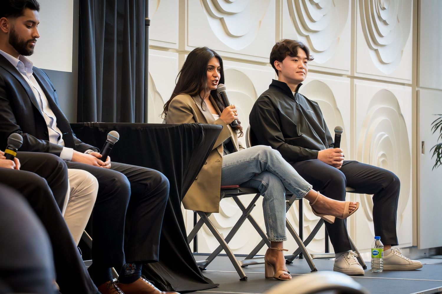 Professional speakers seated in a row during panel discussion event.