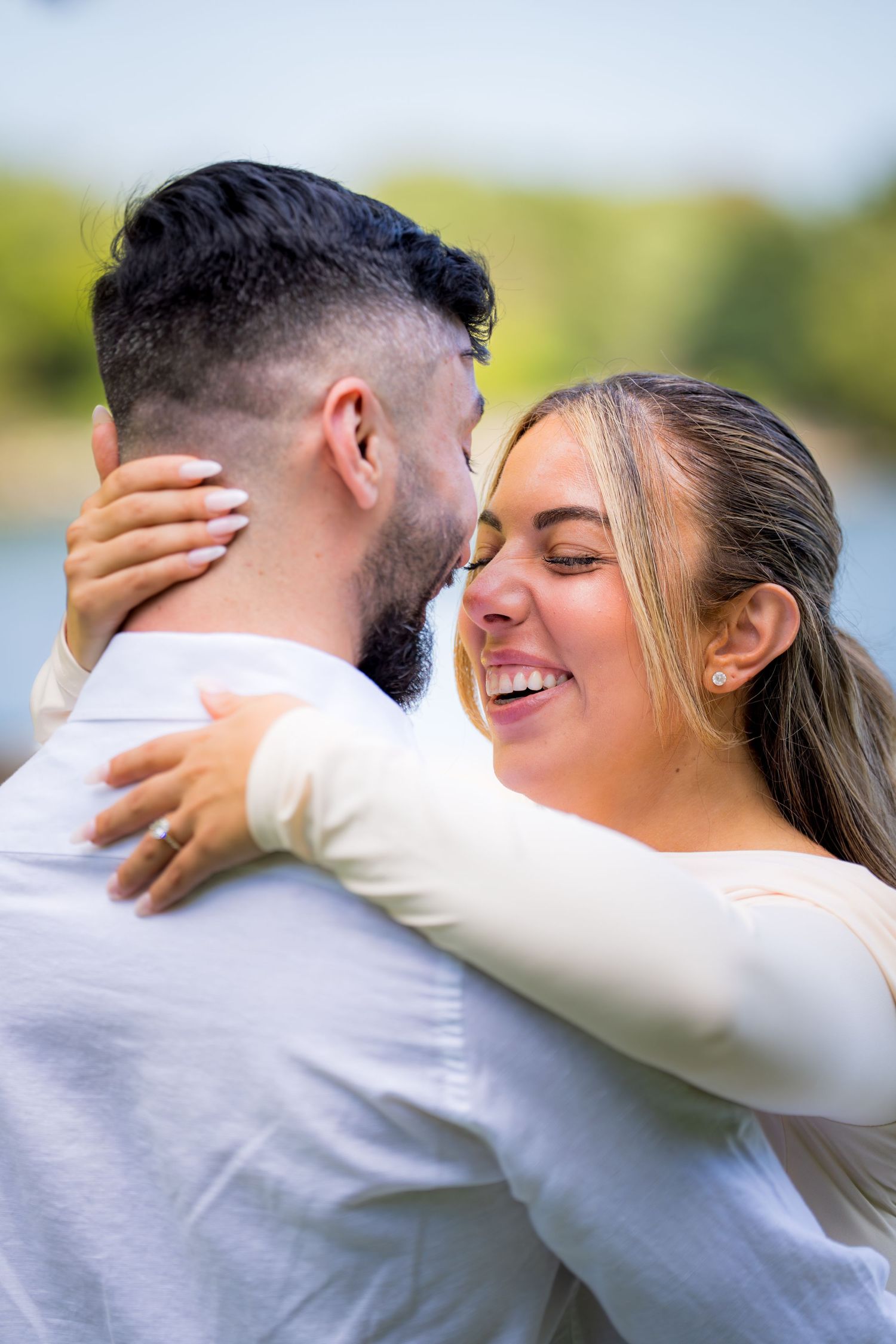 Joyful embrace shared during outdoor wedding photoshoot with floral decorations.