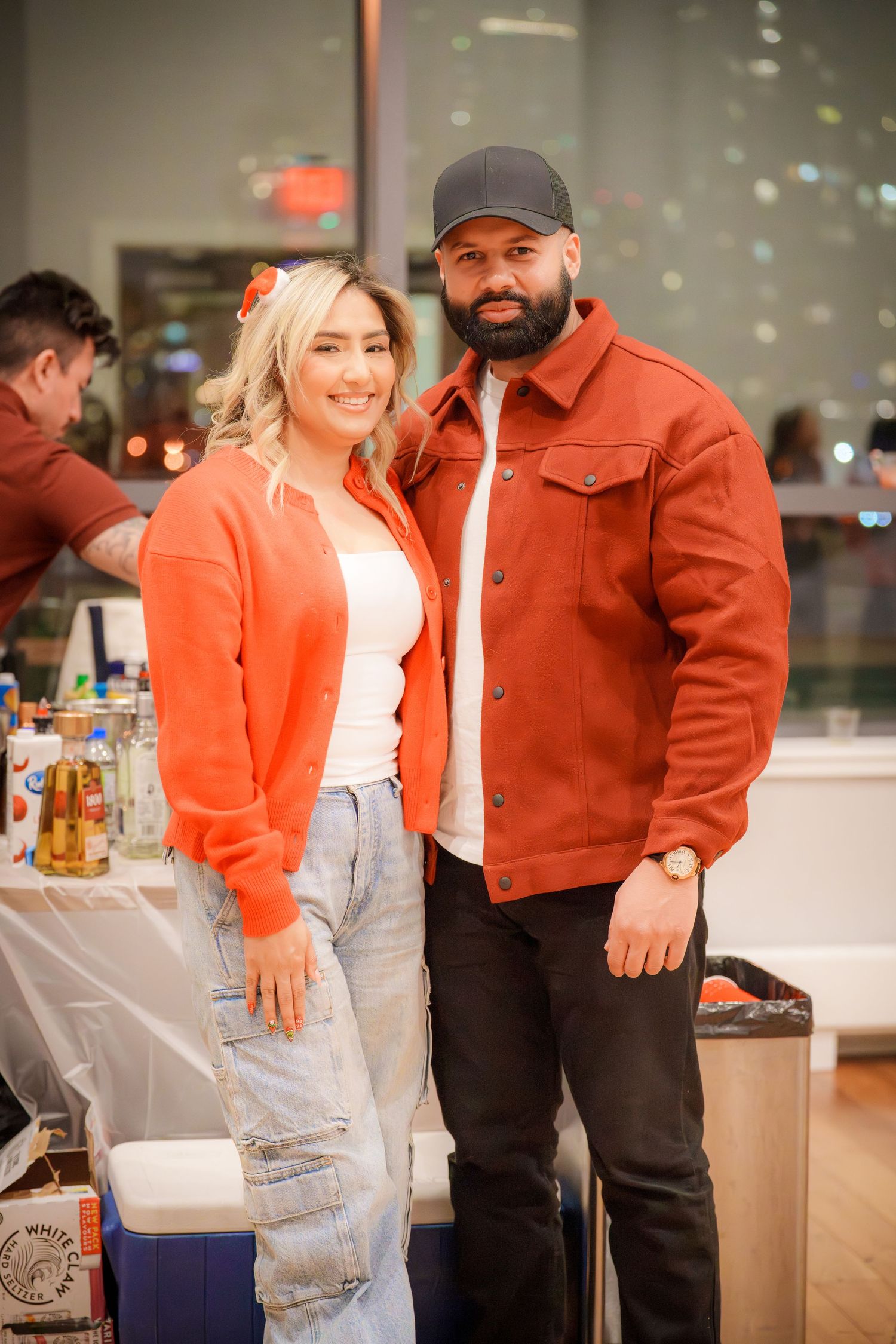 People in stylish outfits including orange jackets and denim at a social gathering.