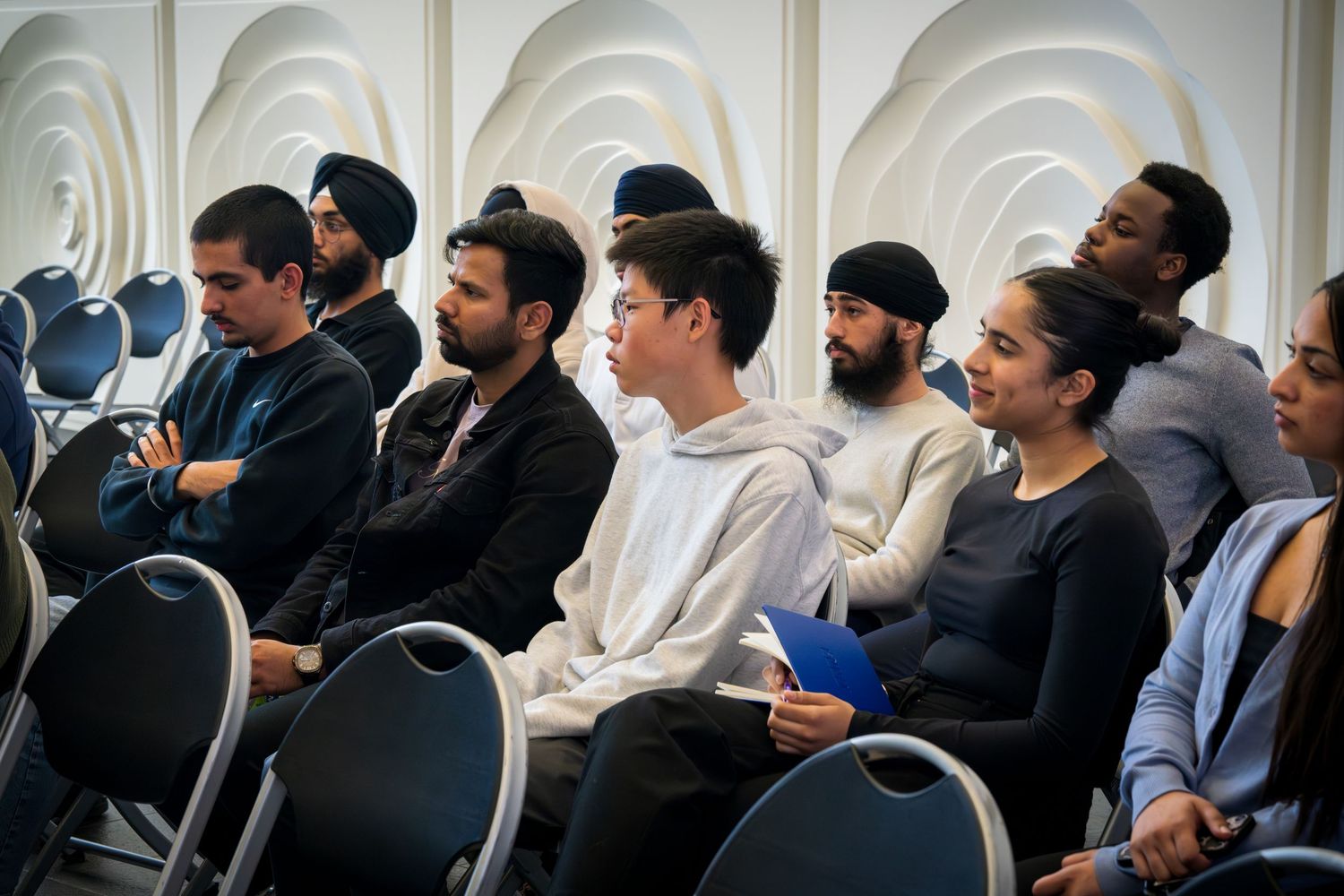 Conference attendees sitting in rows during a presentation in a modern venue.