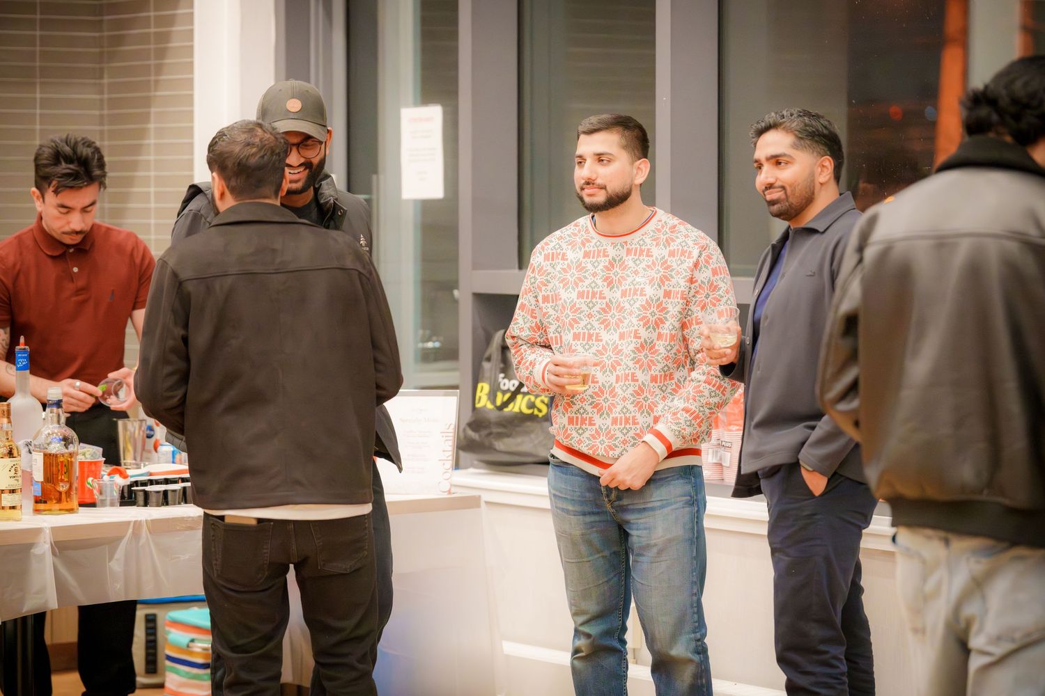 Casual gathering with people standing around in a well-lit indoor space.