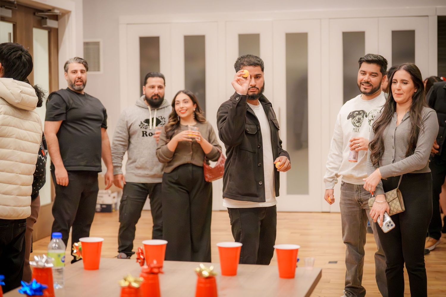 People playing cup games and socializing at an indoor party.