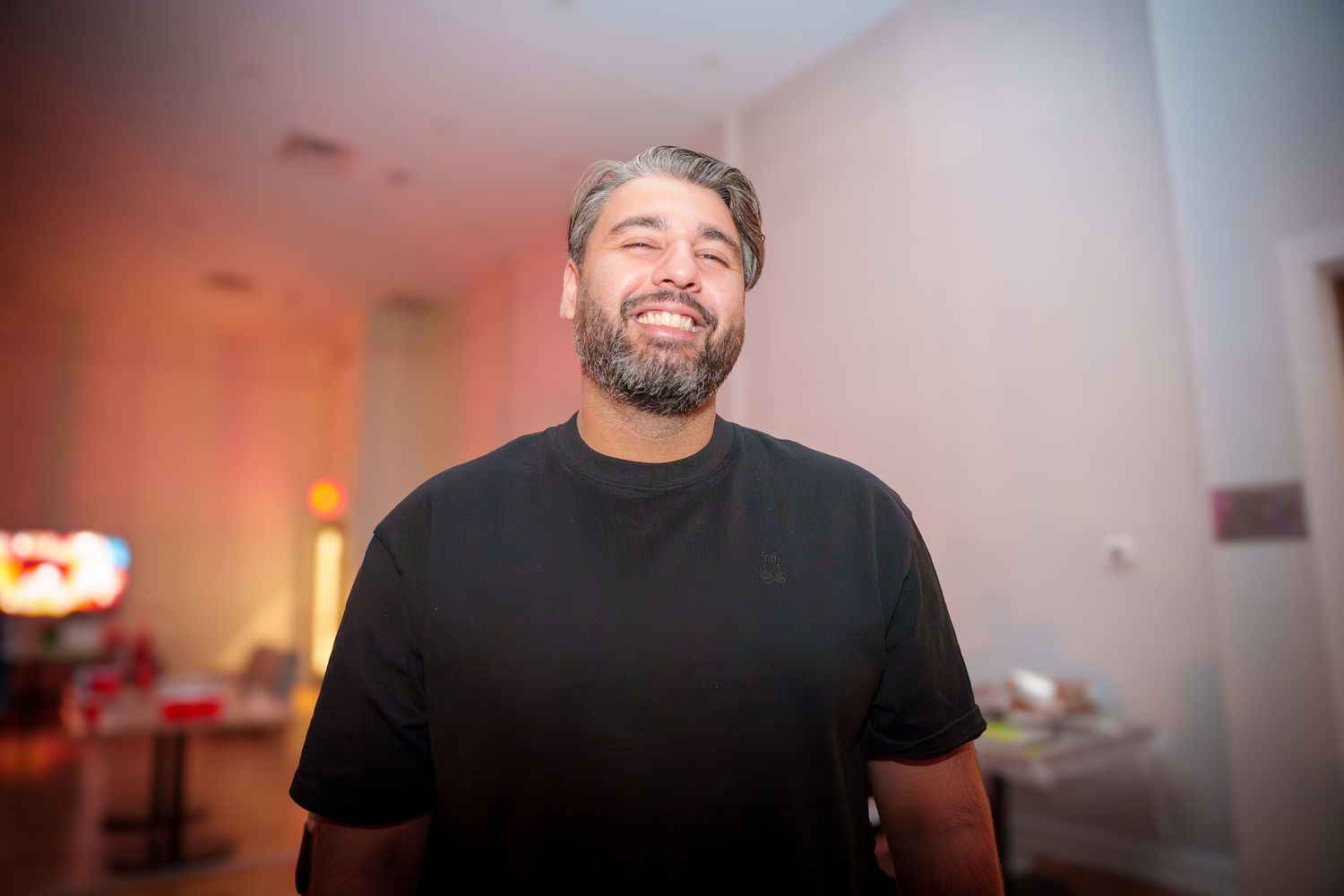 People laughing and having fun at an indoor party with dim lighting.