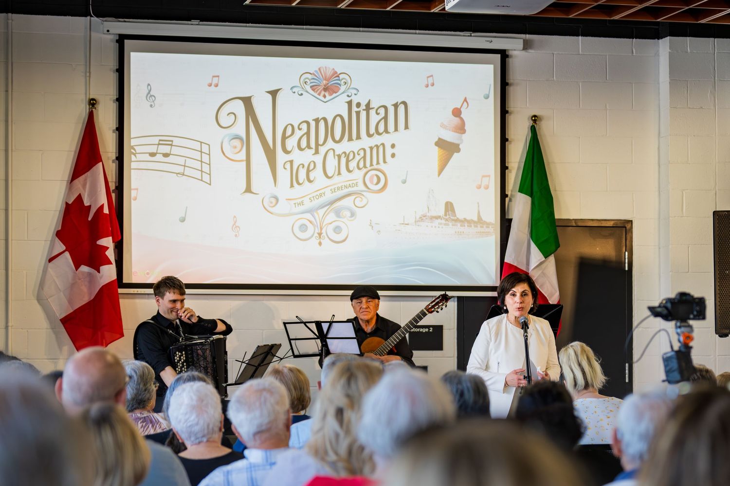 Three performers on stage at Neapolitan Ice Cream musical event with Canadian and Italian flags.