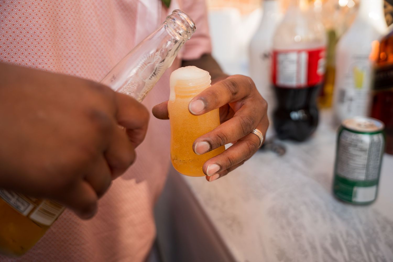Multiple hands raising beer glasses together for a group toast.