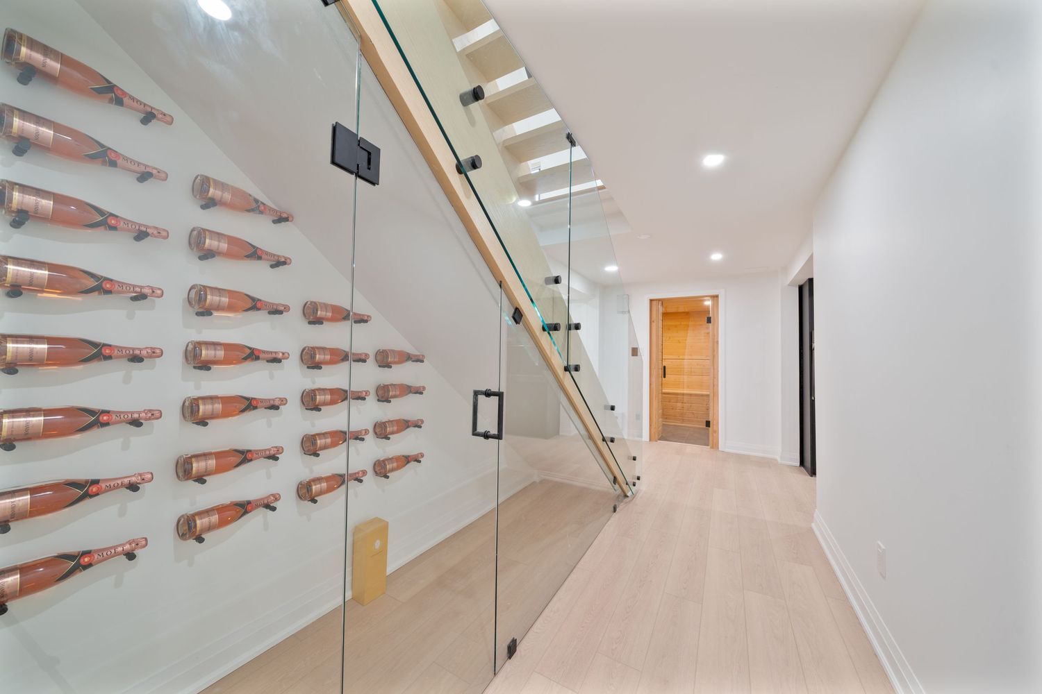 A white modern hallway with floating shelves displaying multiple orange rifles mounted on the wall.